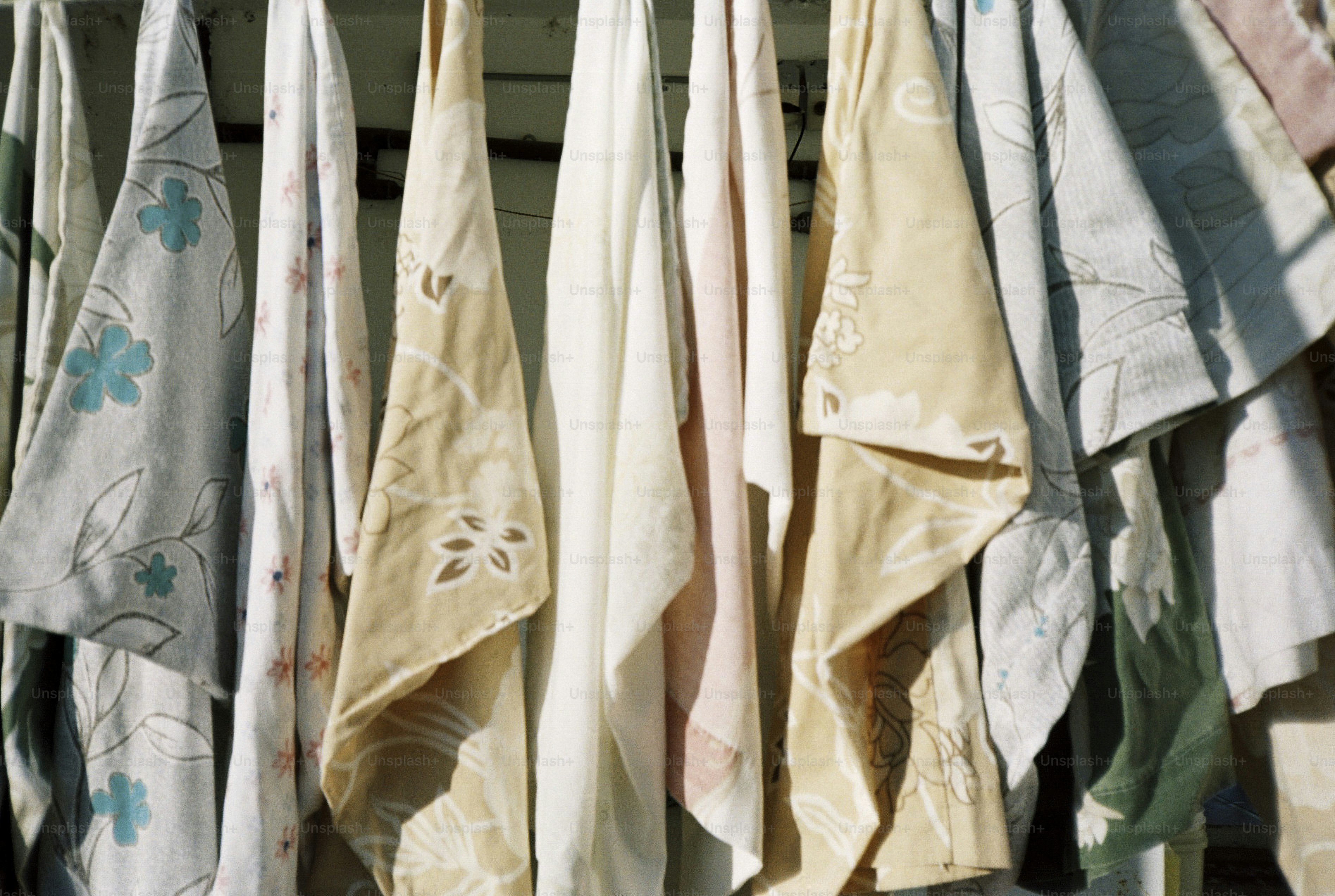 Colorful patterned fabrics hanging on a rack.