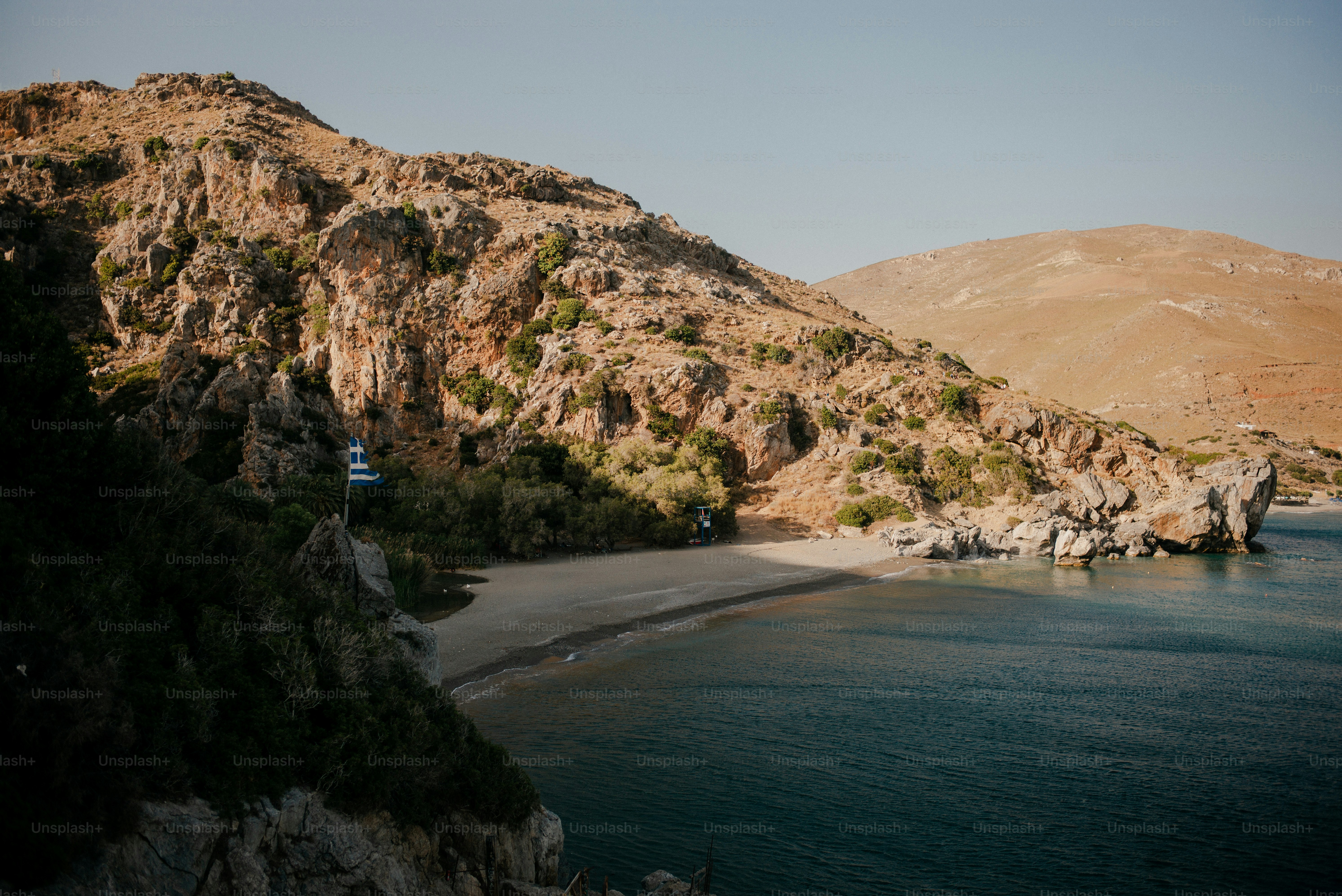Rocky coastline with a secluded beach and calm sea.