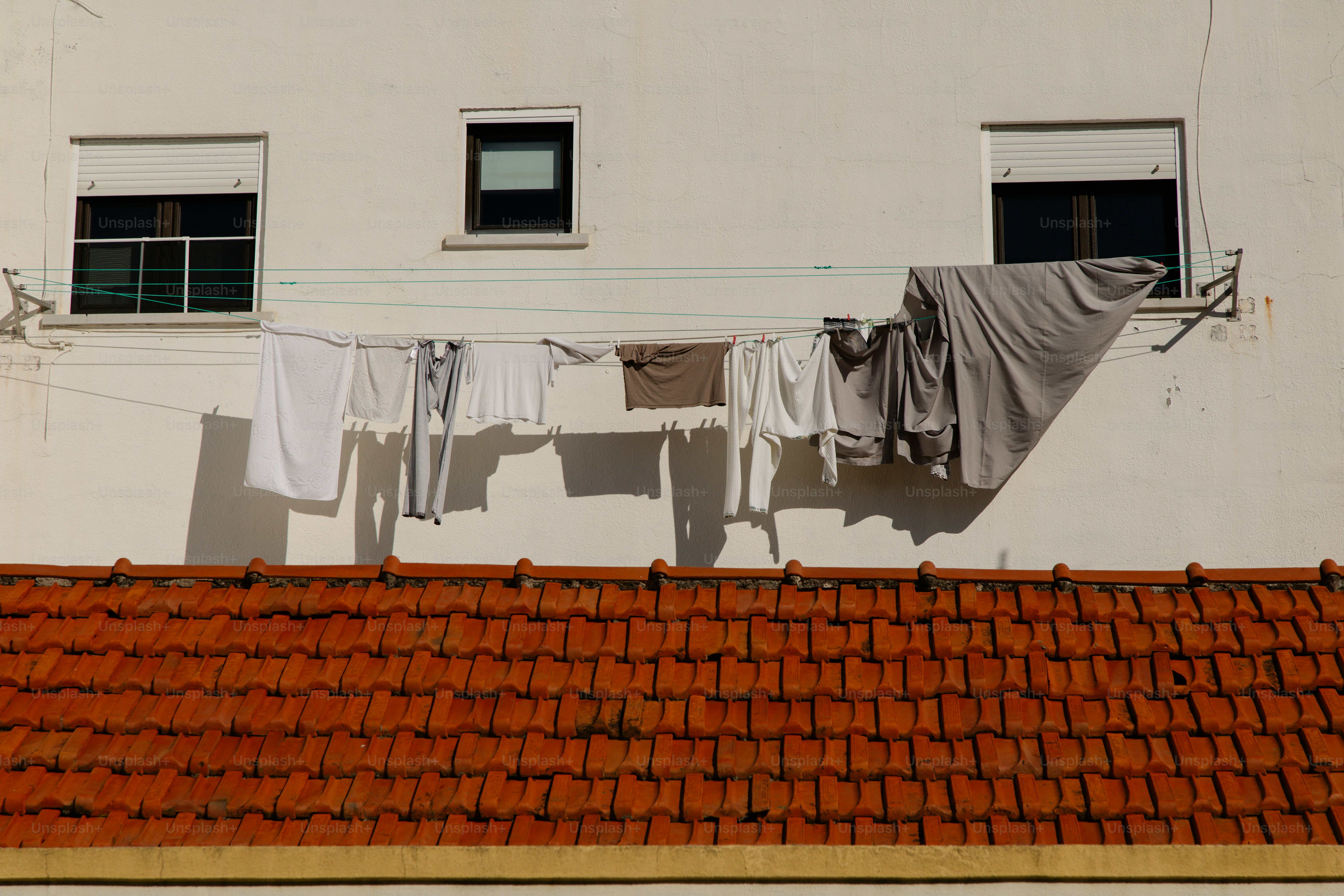 Kleidung, die an einer Leine vor einem Gebäude trocknet.