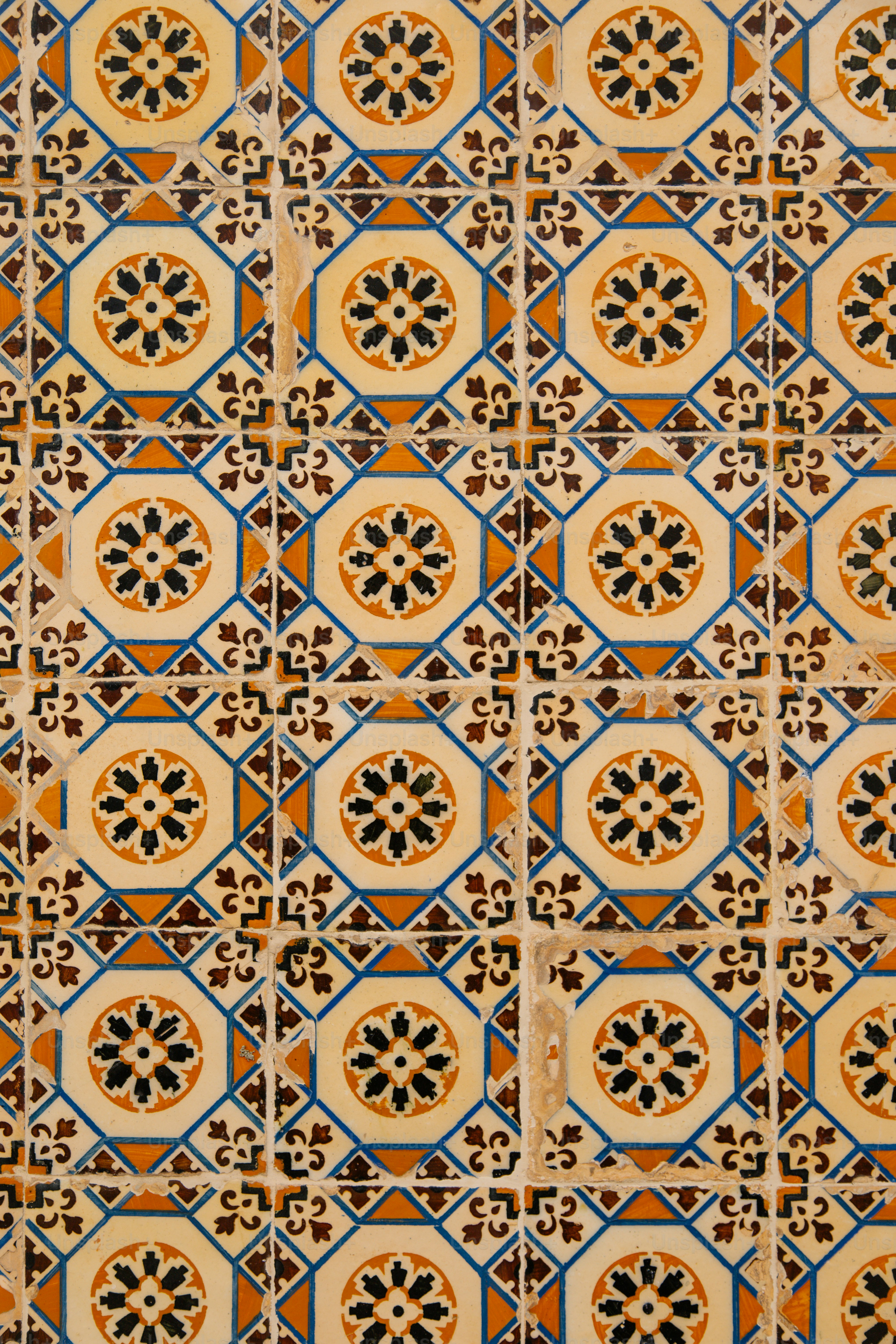 Verzierte gemusterte Fliesen mit floralen Motiven in Gelb und Blau.