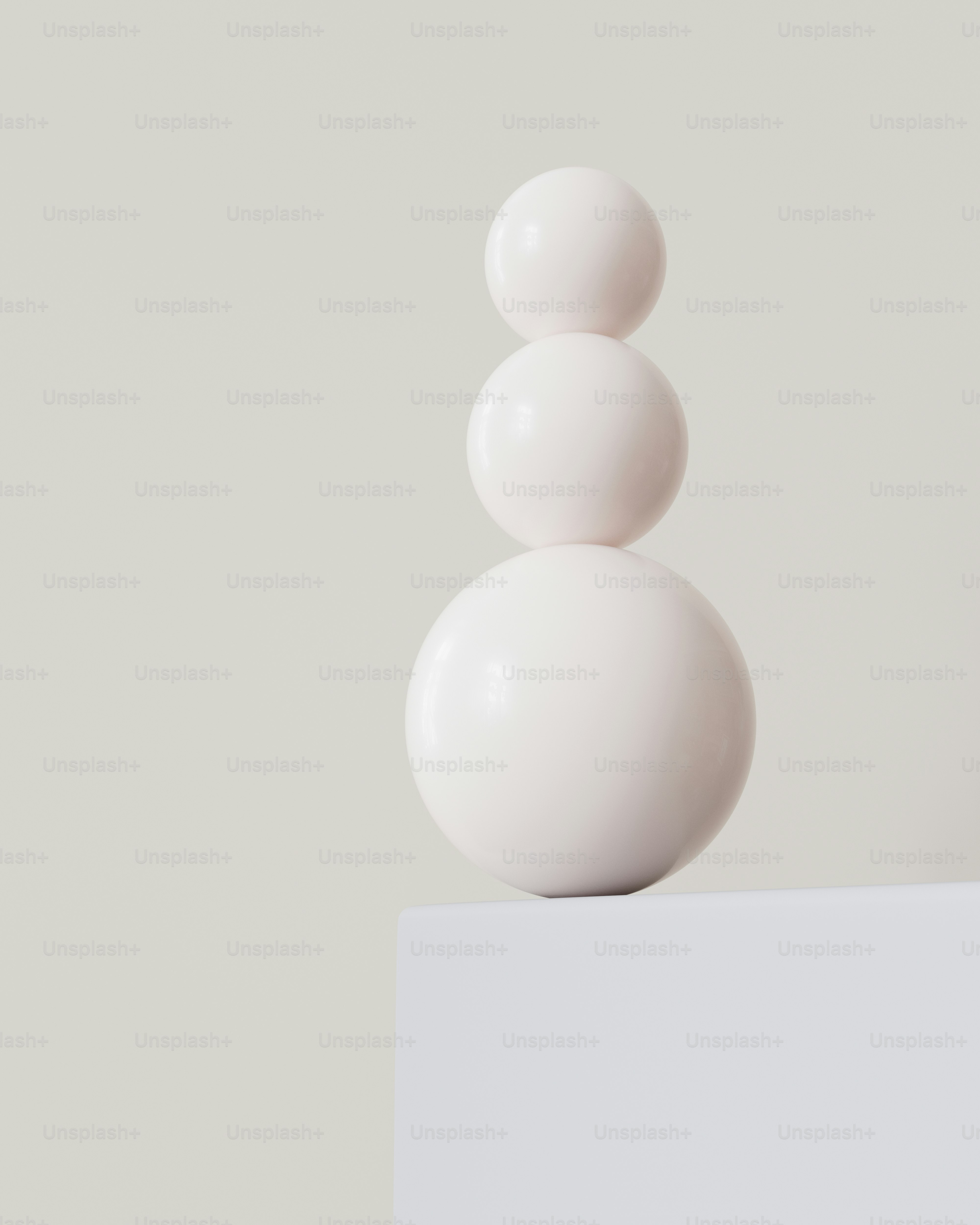 Three stacked white spheres on a white surface