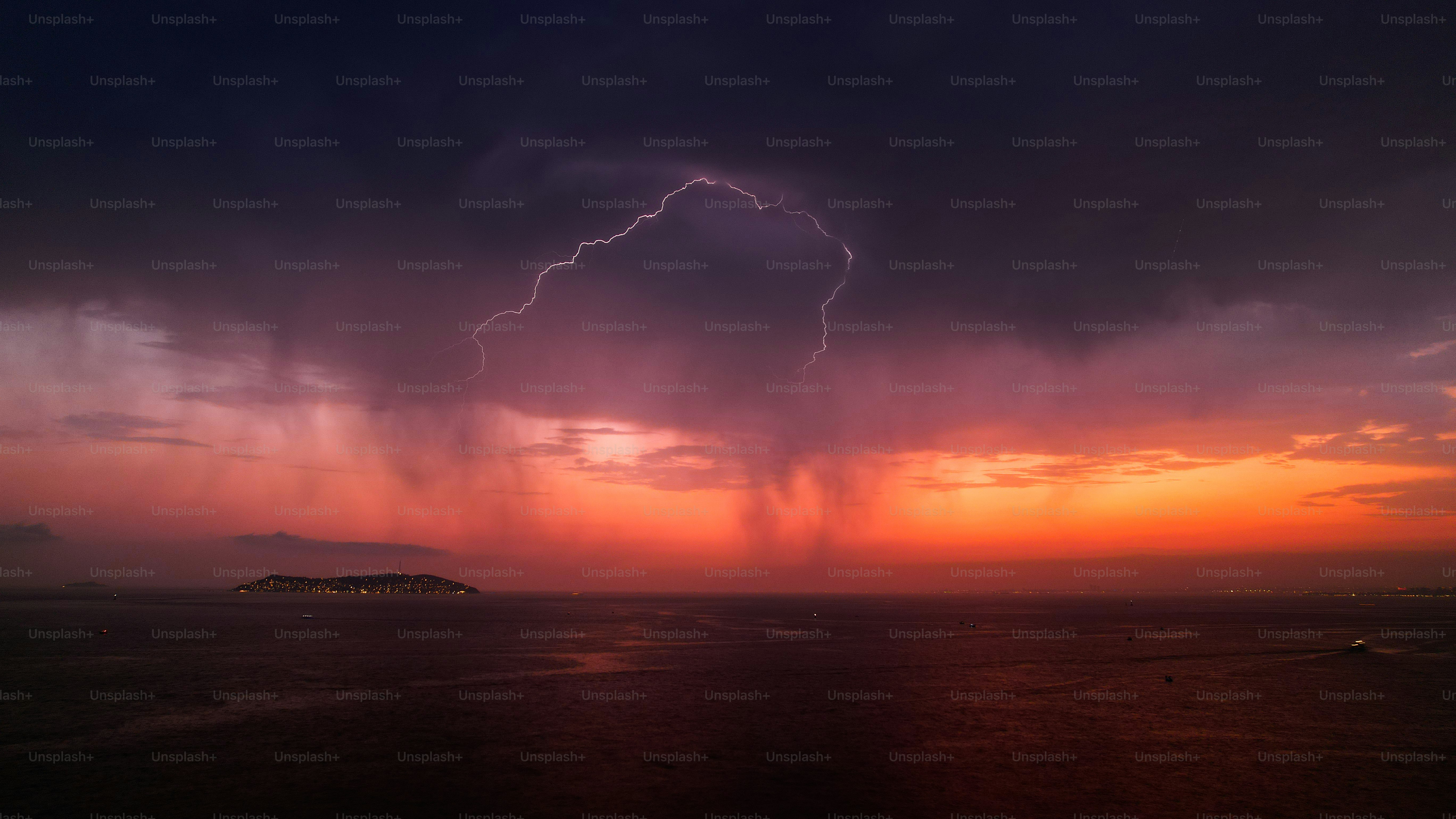 Lightning strike over the ocean during a dramatic sunset
