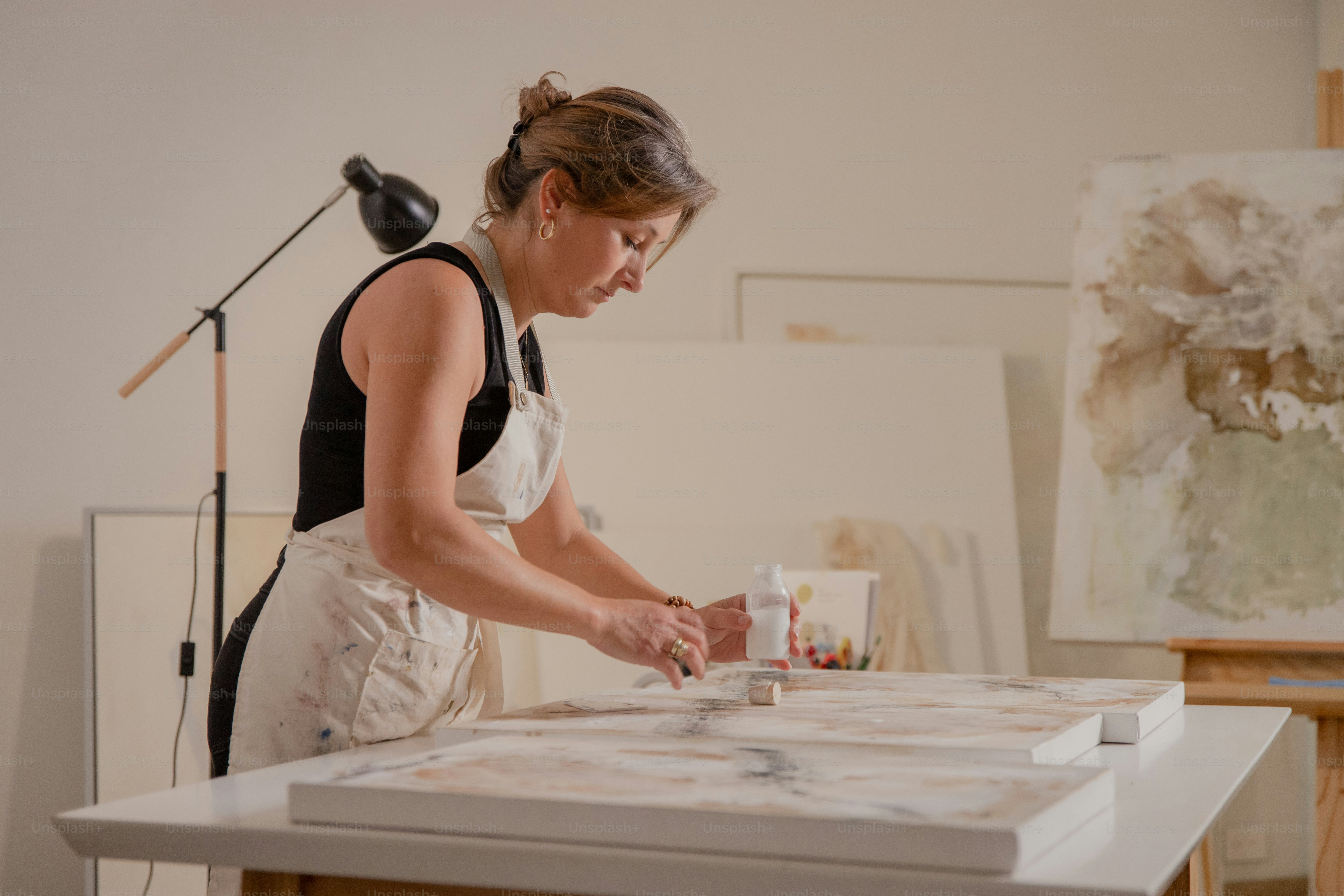 Artist working on a painting in a studio.