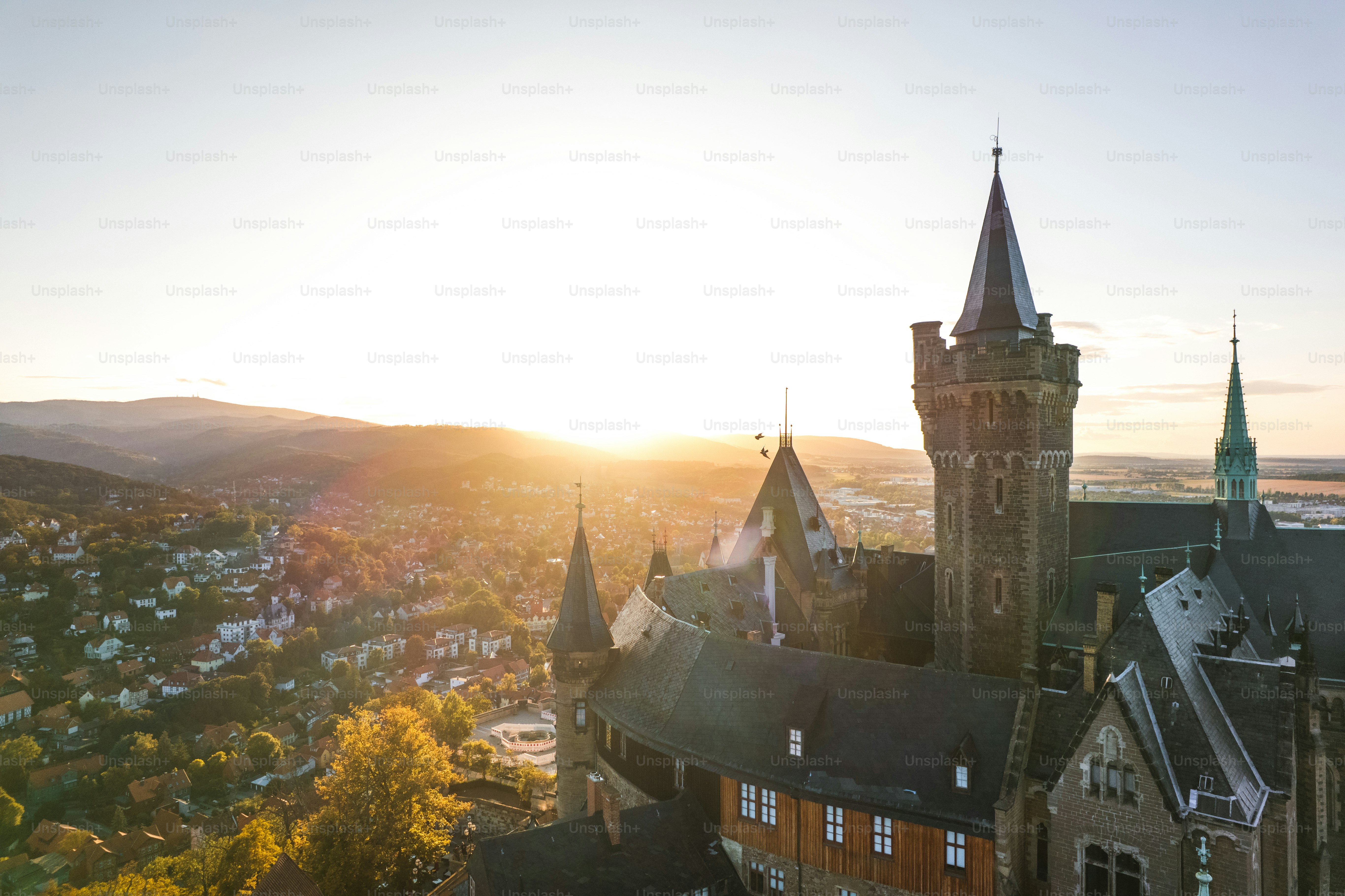 Torres del castillo al amanecer con colinas onduladas abajo
