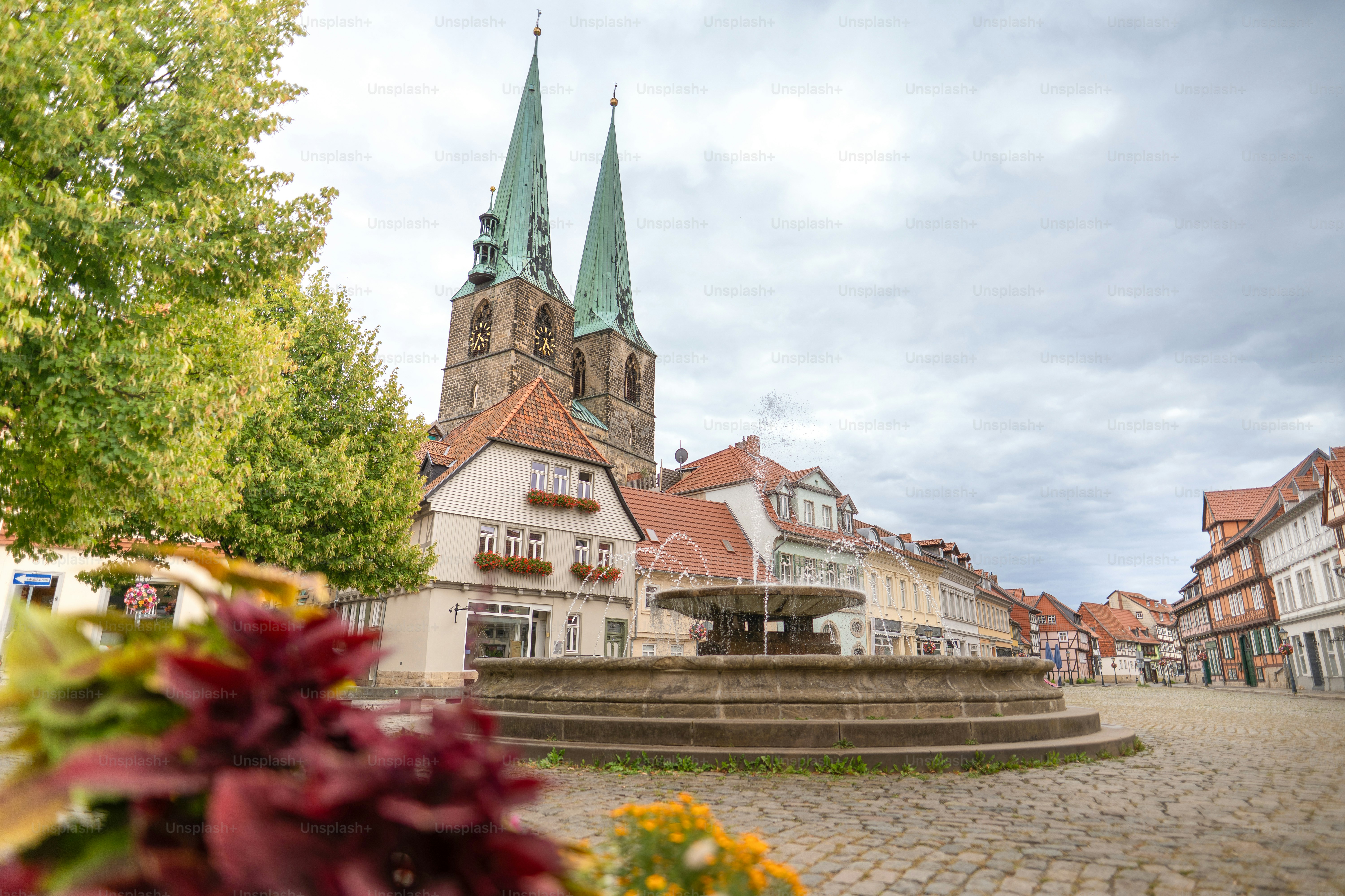 Historischer Stadtplatz mit Kirche und Brunnen.