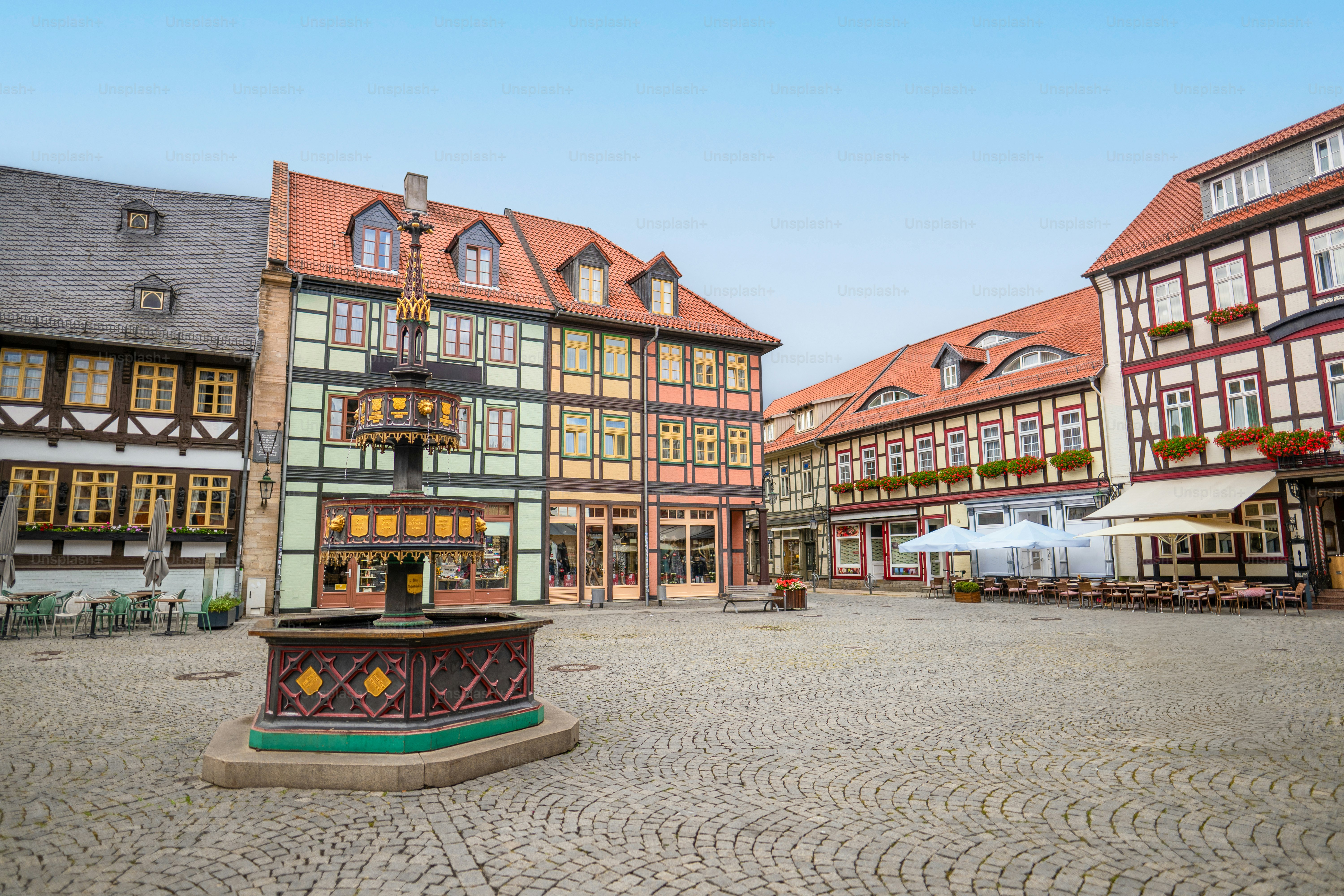Historische Fachwerkgebäude umgeben einen steinernen Brunnen.