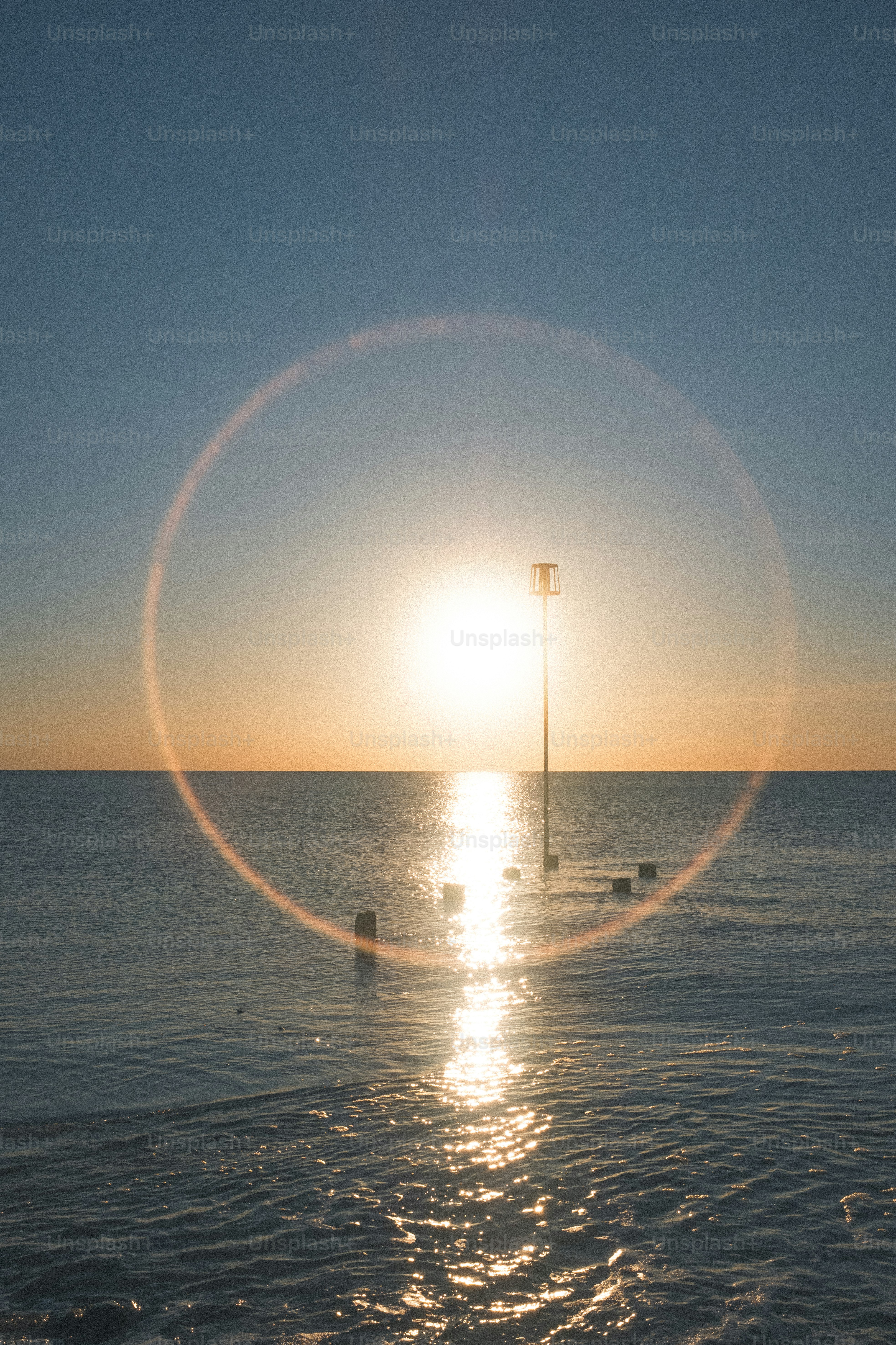 Sun setting over the ocean with lens flare.