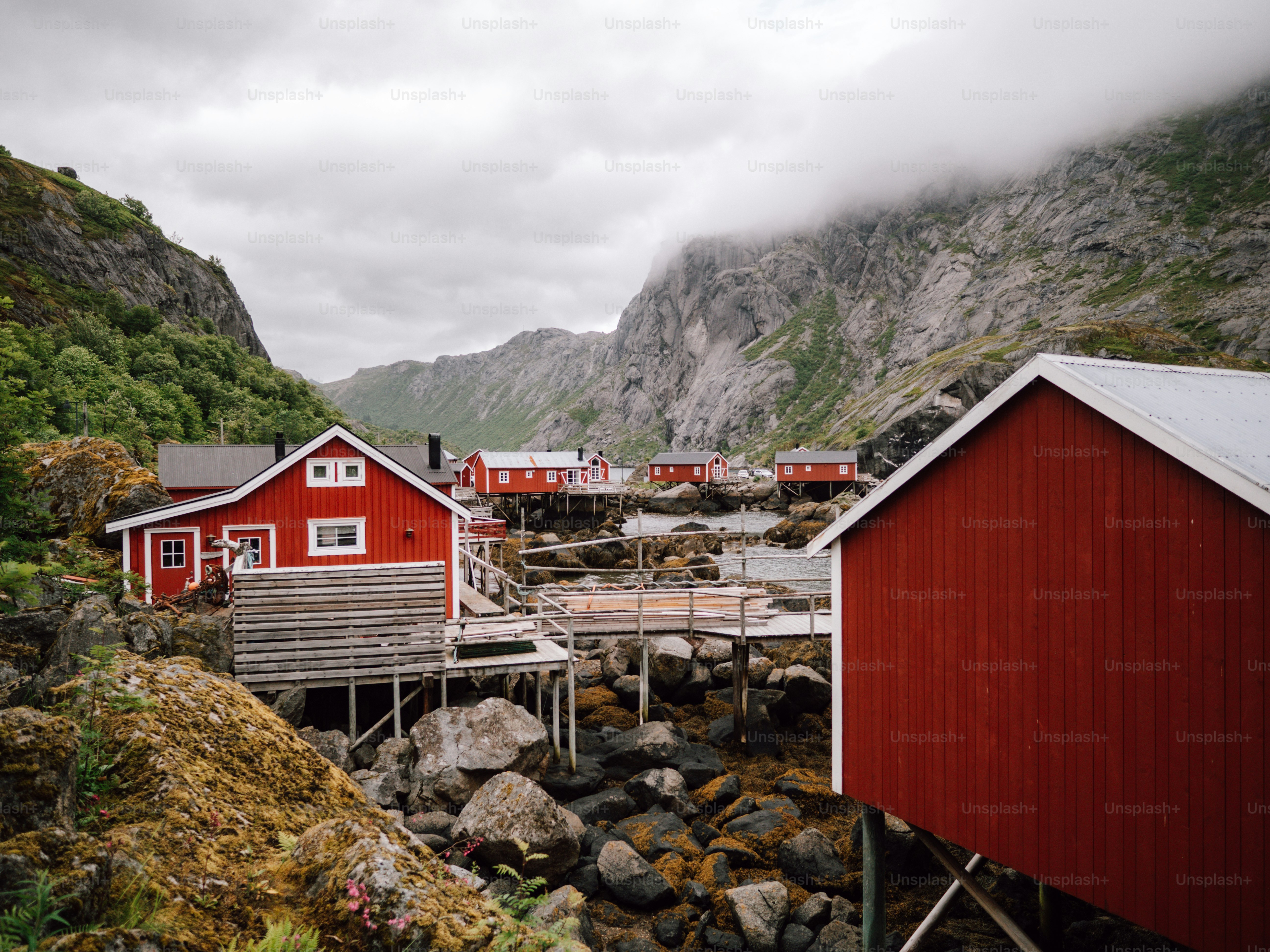 Cabañas de pesca rojas sobre pilotes junto a la costa rocosa