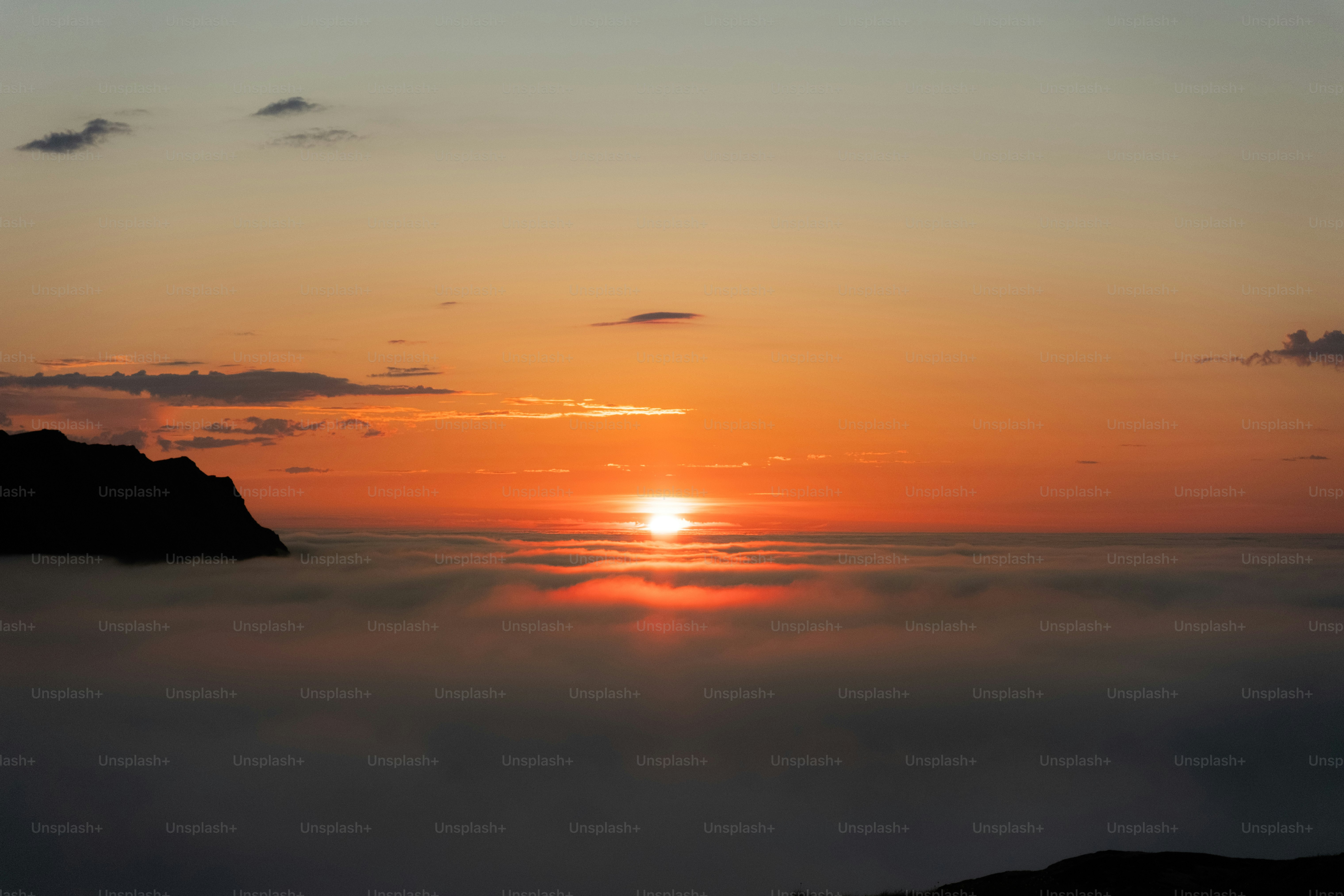 Sunset over clouds with mountain silhouette