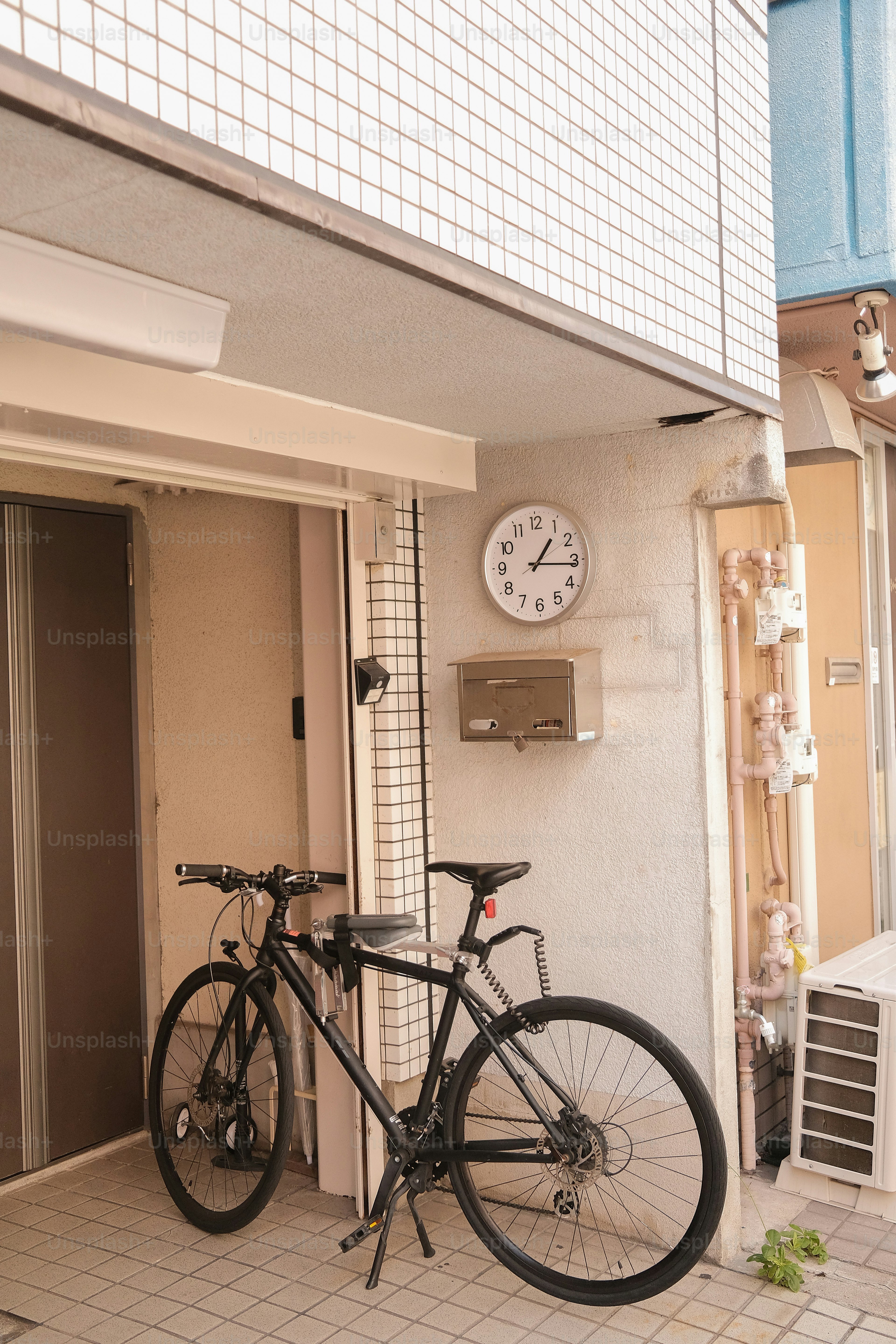 Ein schwarzes Fahrrad parkte in der Nähe eines Gebäudeeingangs.