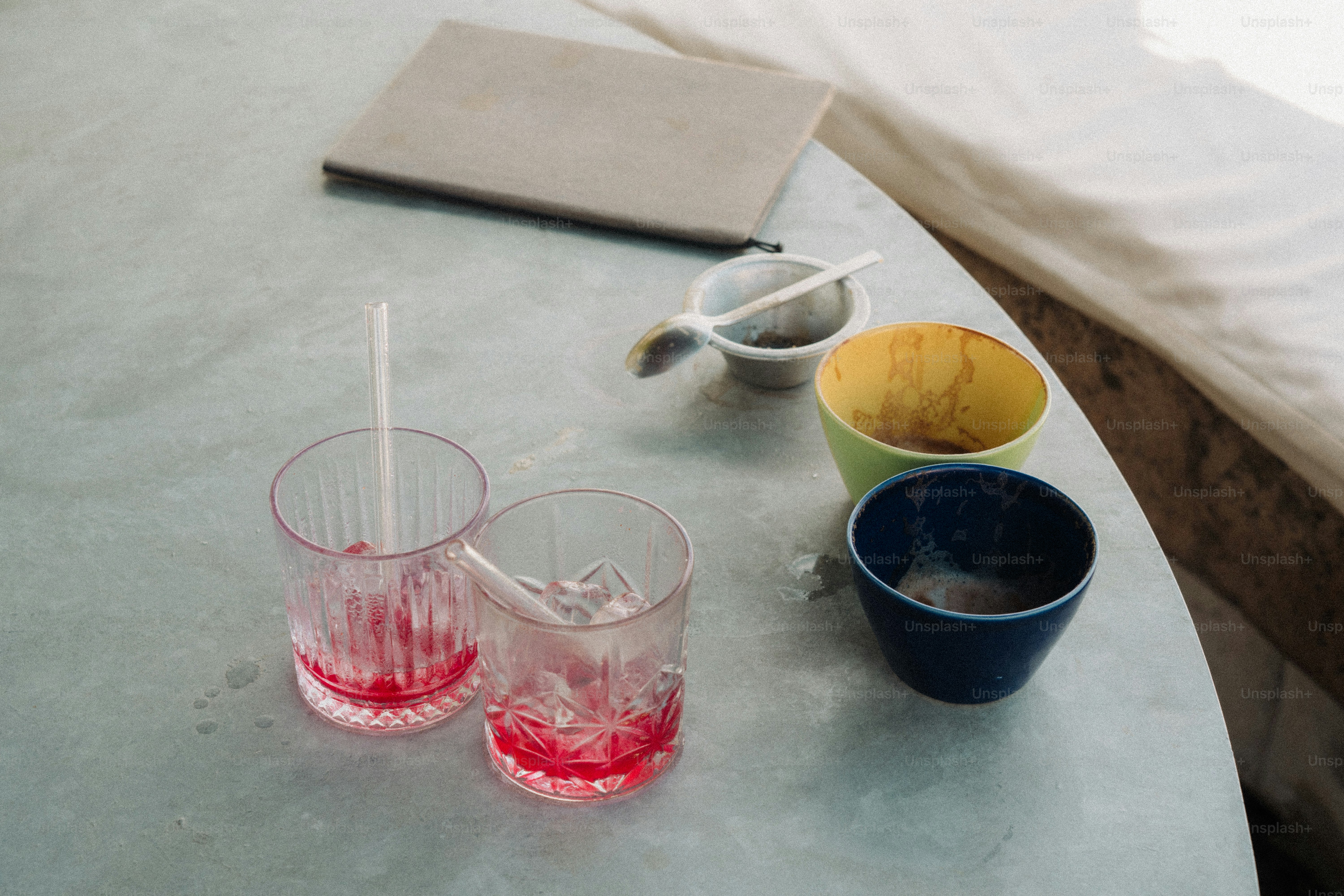 Two glasses with red liquid and ice cubes on table