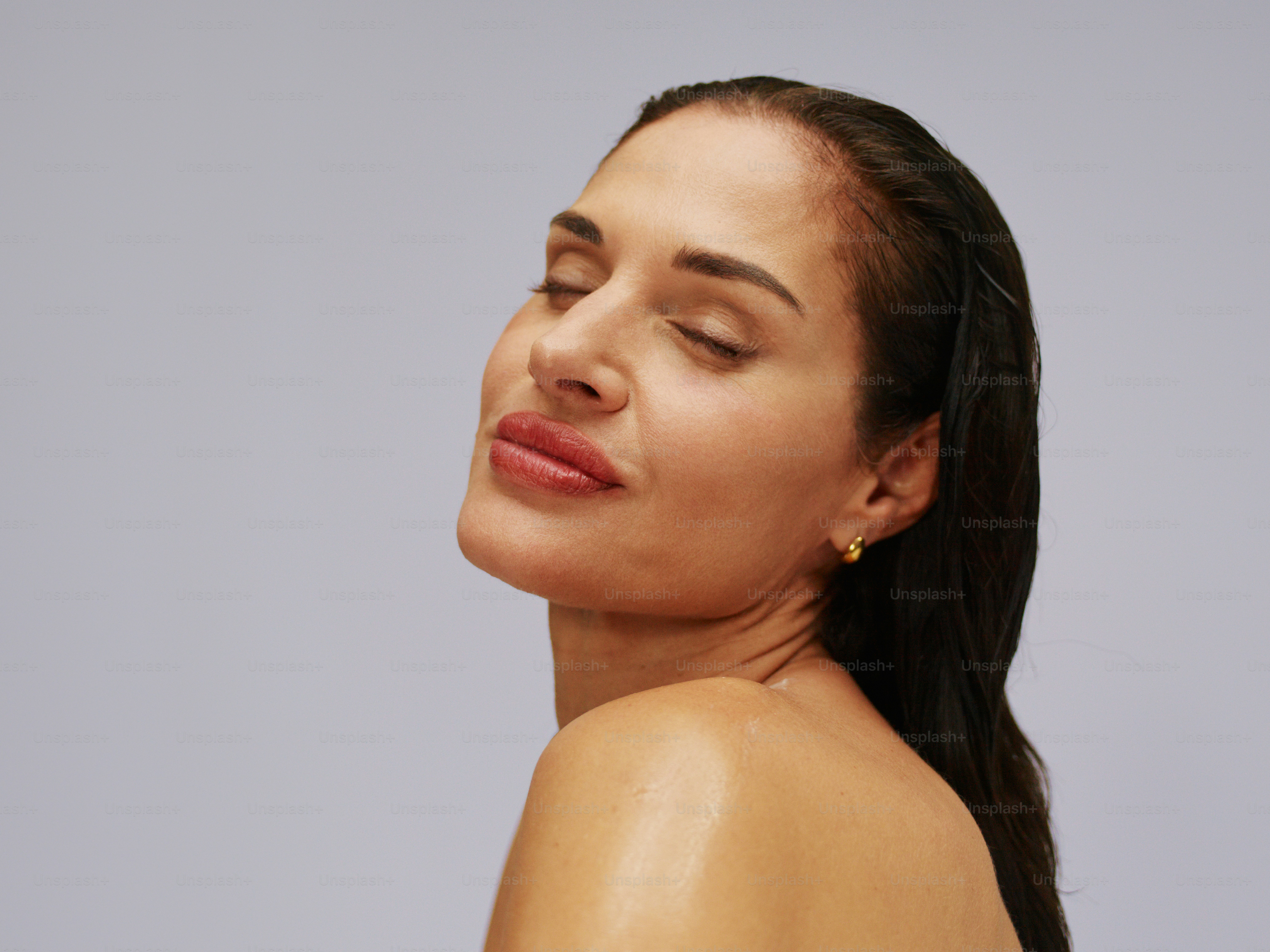 Mulher de olhos fechados, cabeça inclinada para trás, aproveitando a luz do sol.