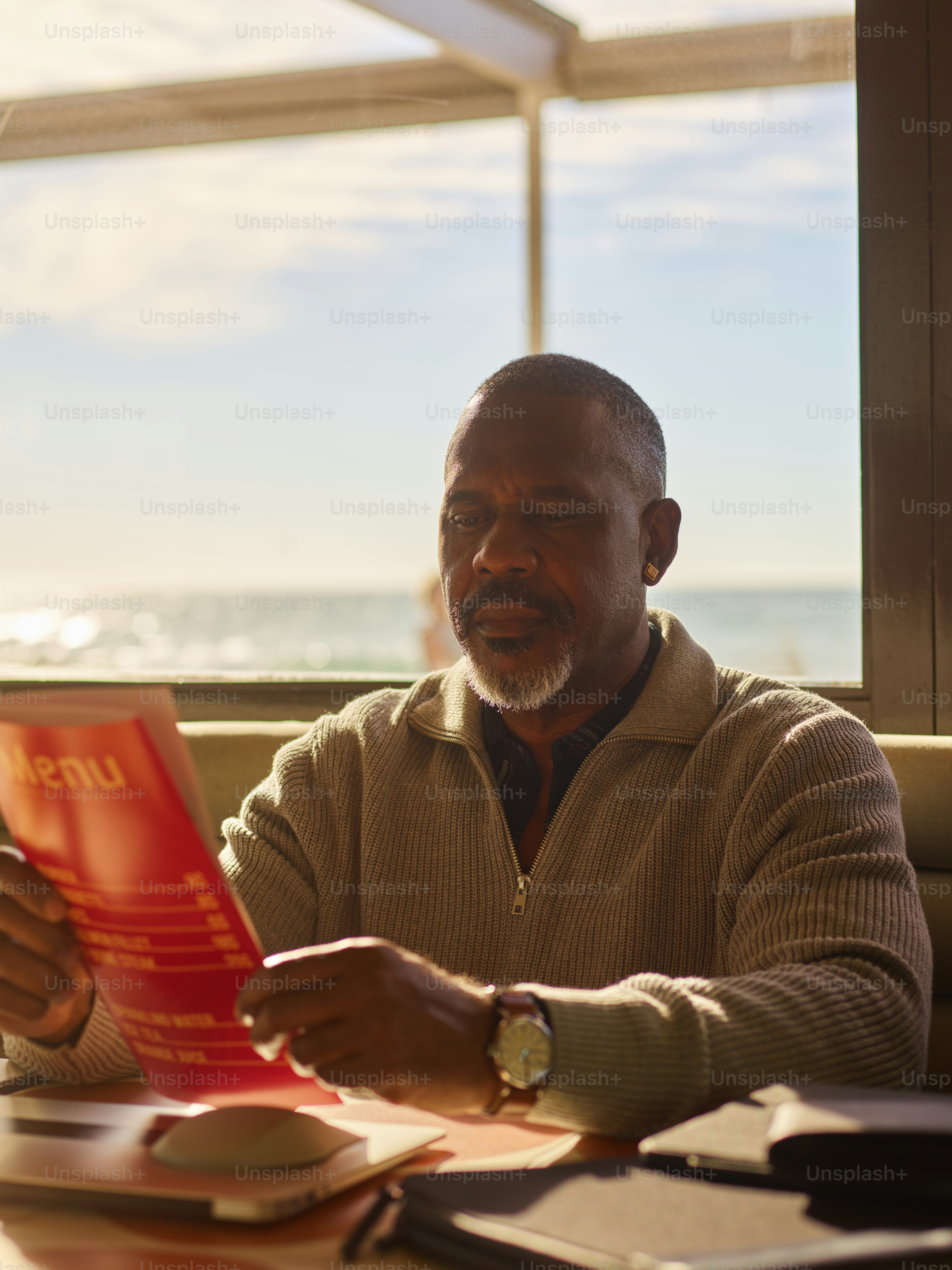 Man reading a menu at a seaside restaurant. photo – Restaurant Image on ...