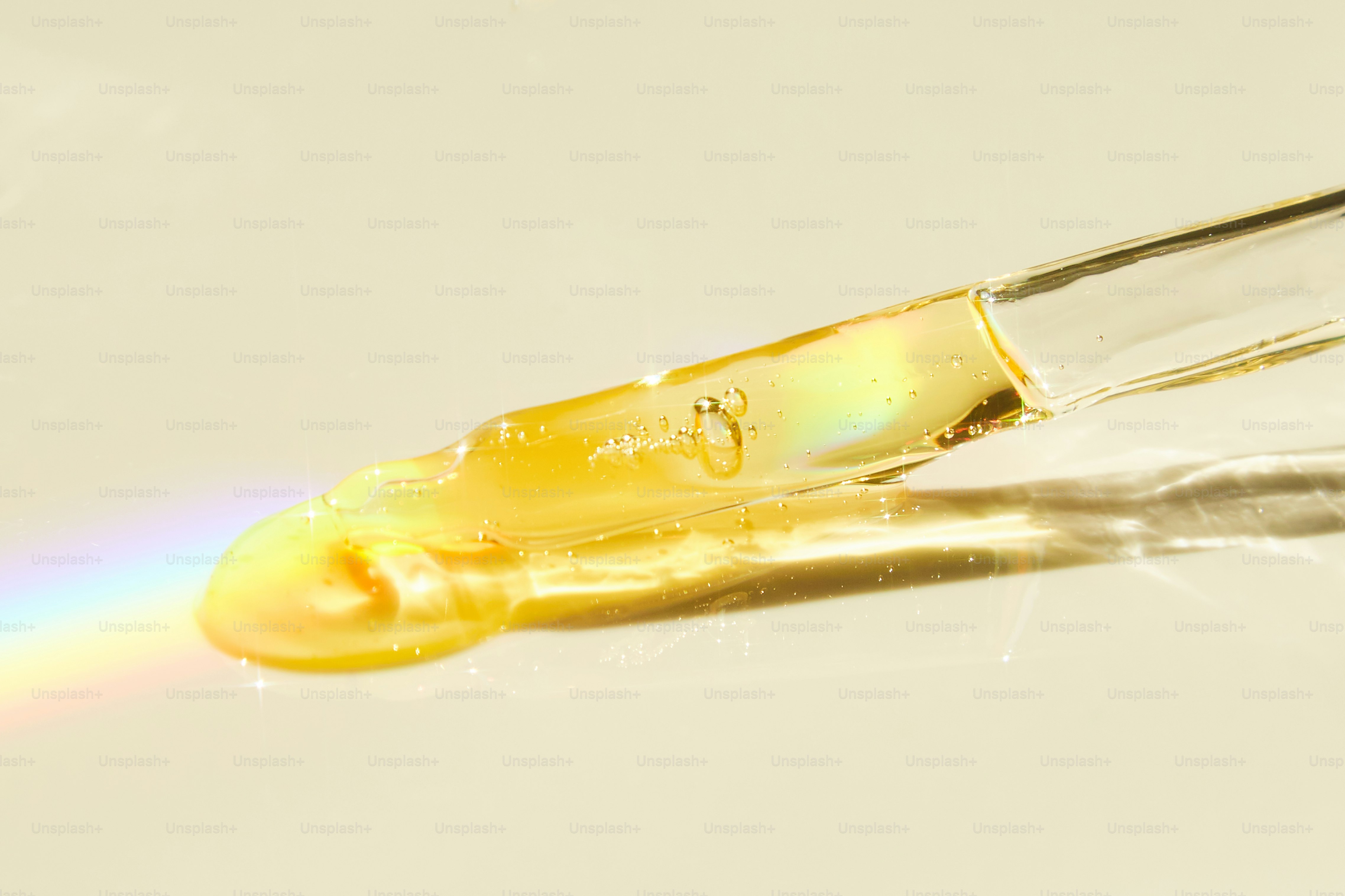 A drop of golden liquid from a dropper.