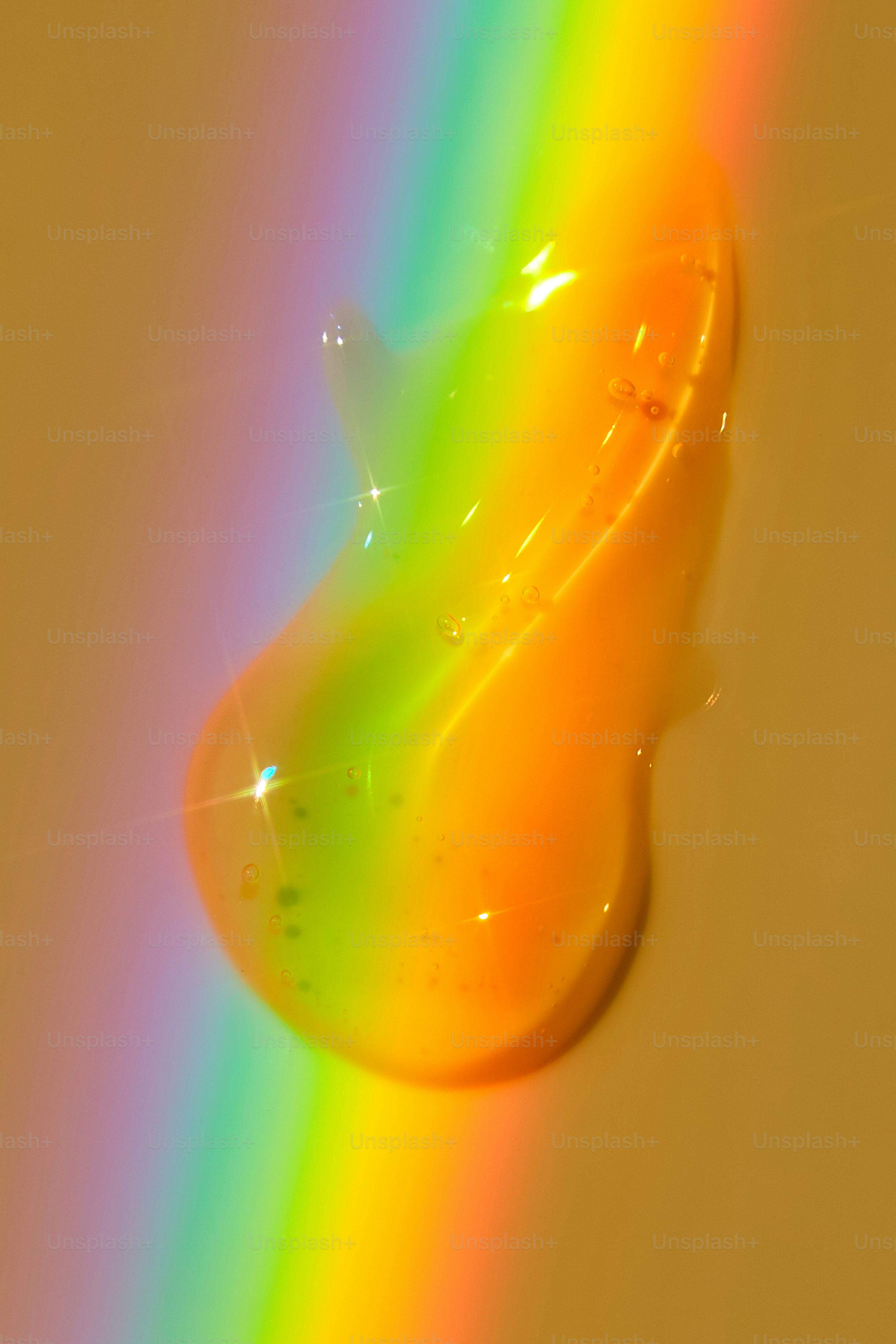 Uma gota de líquido laranja com reflexo de luz arco-íris