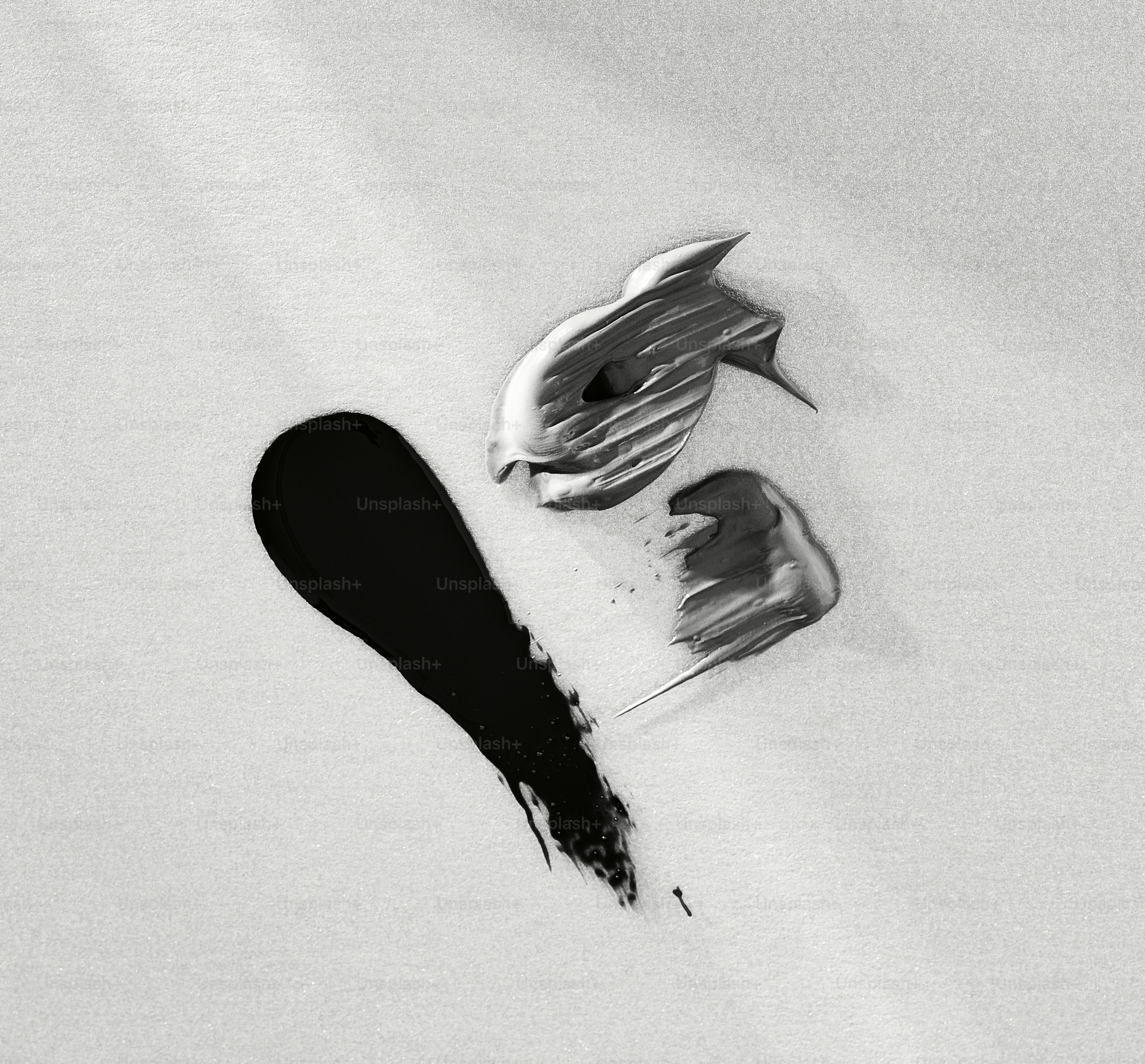 A metallic fish shape with black paint strokes.