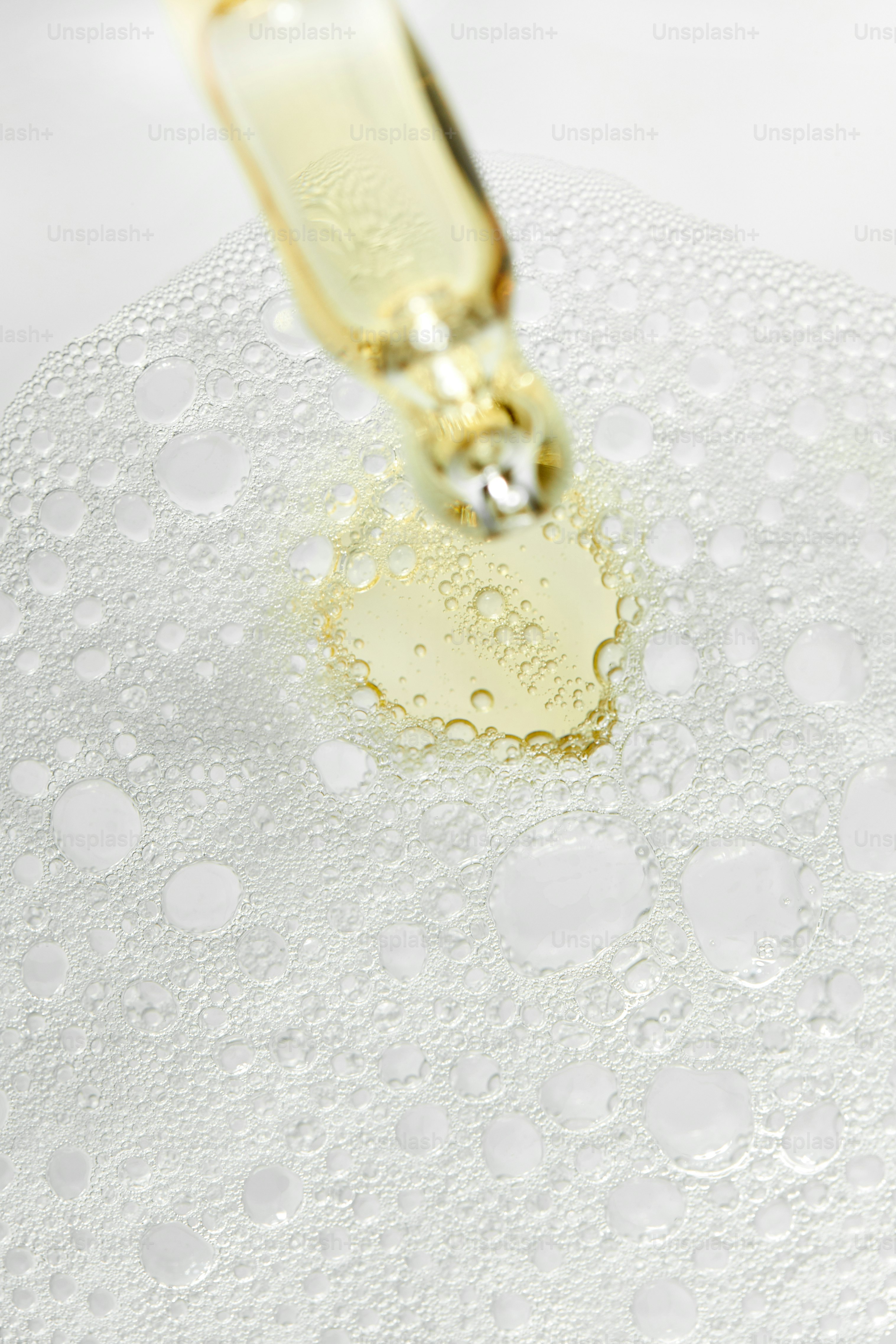 Compte-gouttes libérant un liquide jaune en bulles