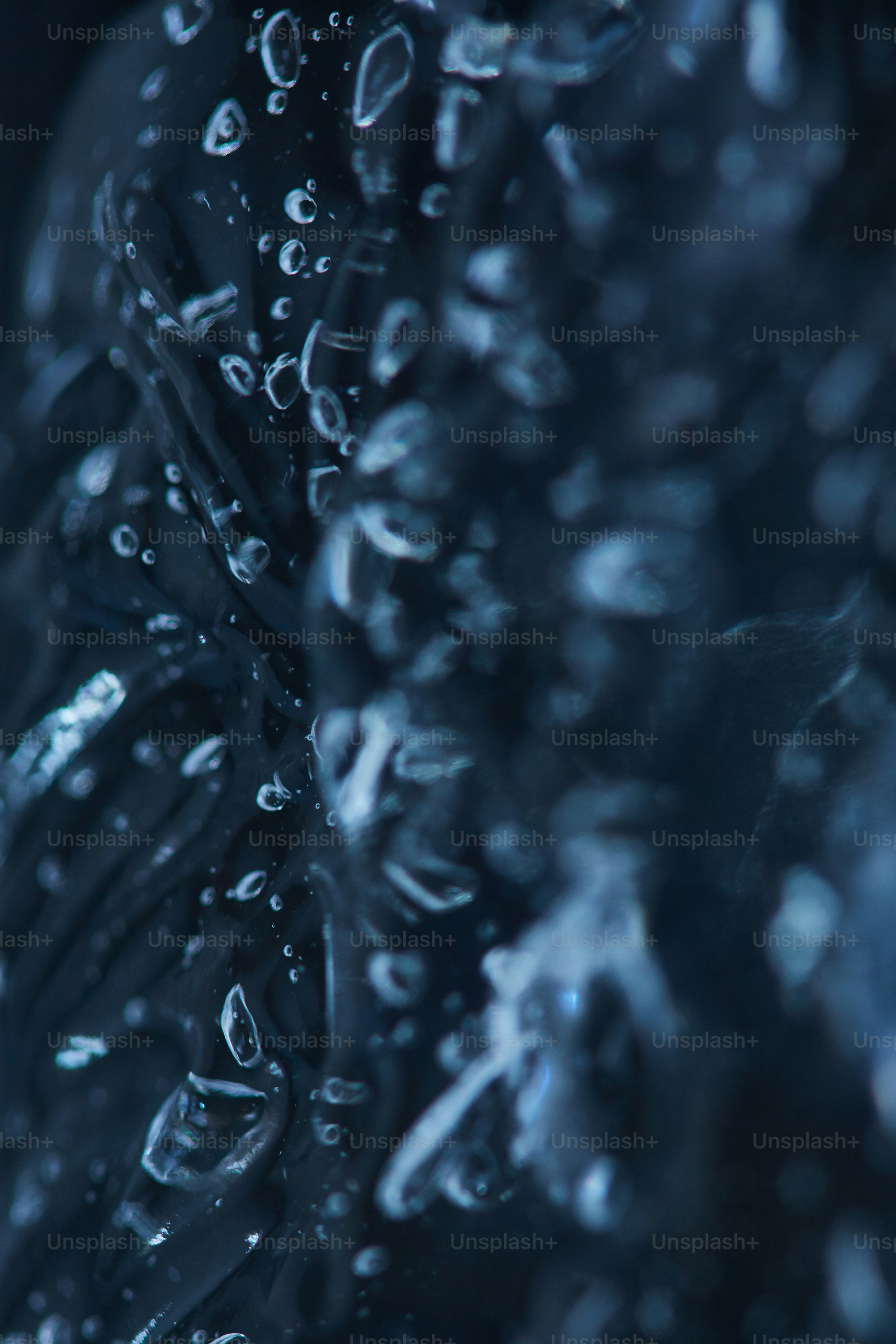 Close-up of water droplets on a dark, textured surface.