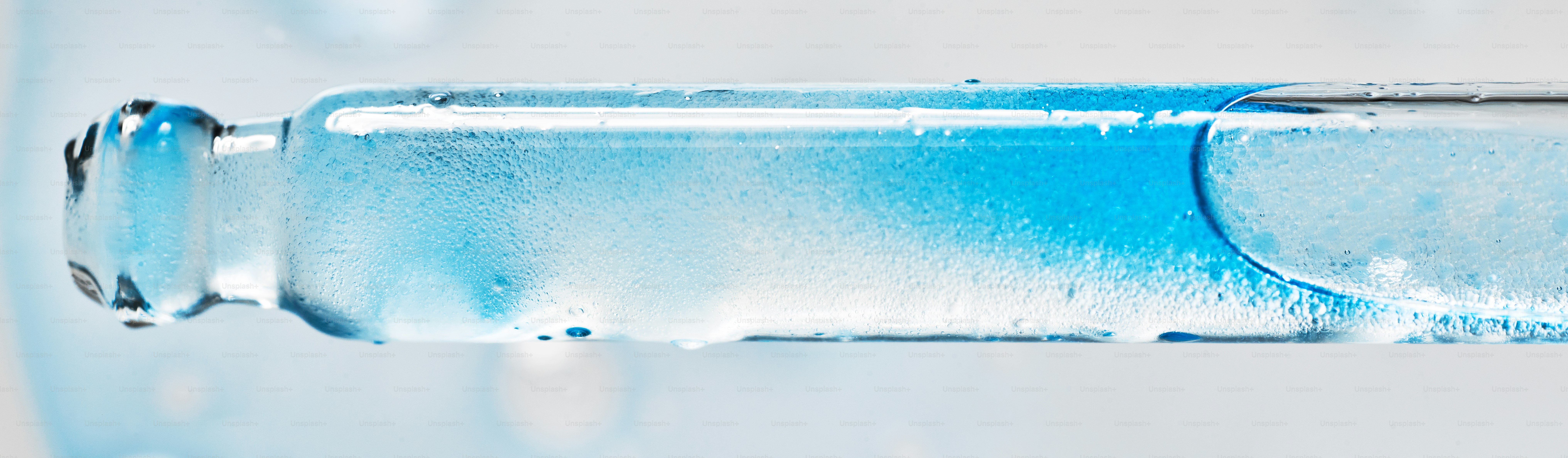 Líquido azul em conta-gotas de vidro com bolhas