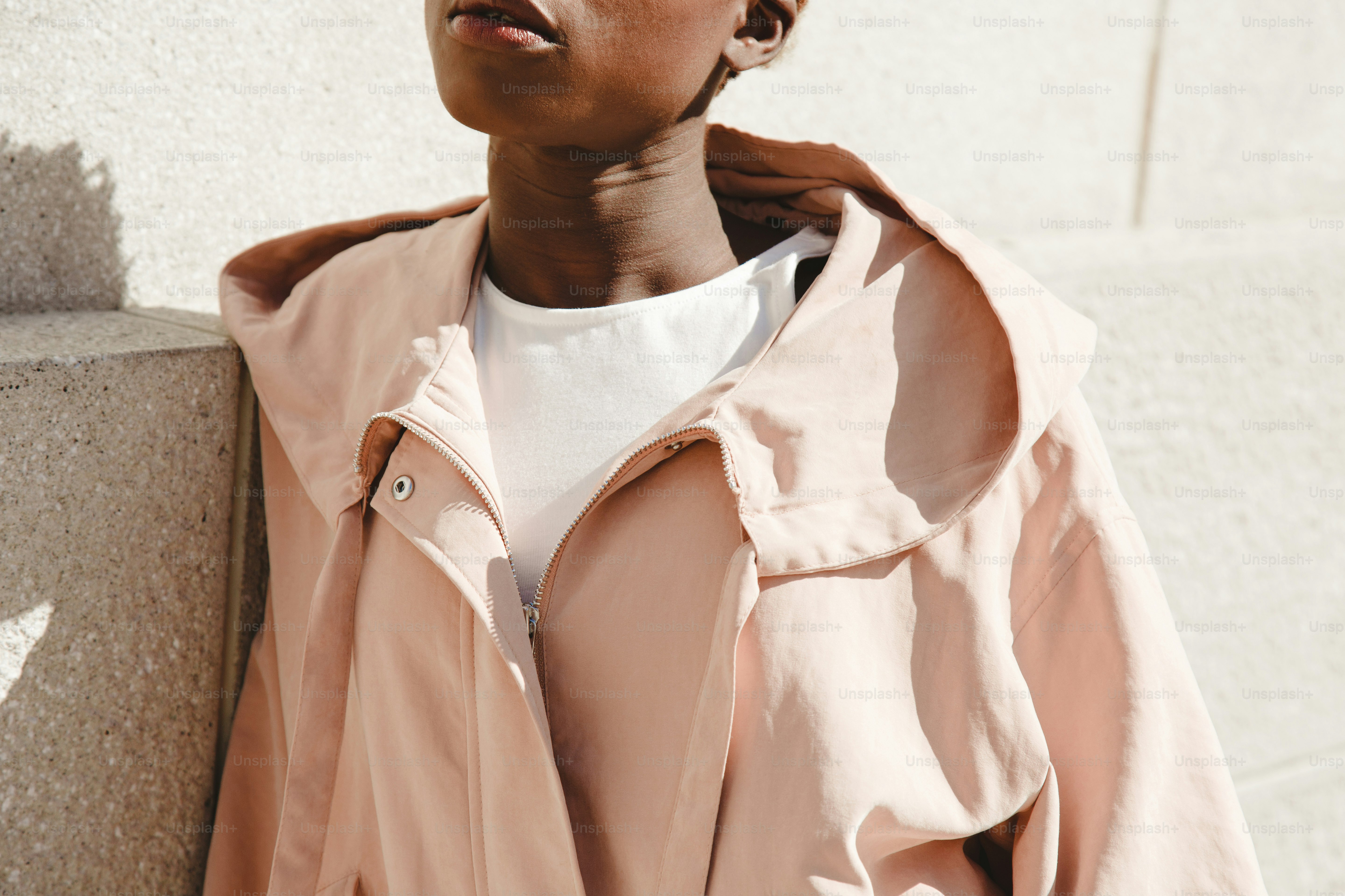 A young woman wearing a pink hooded jacket