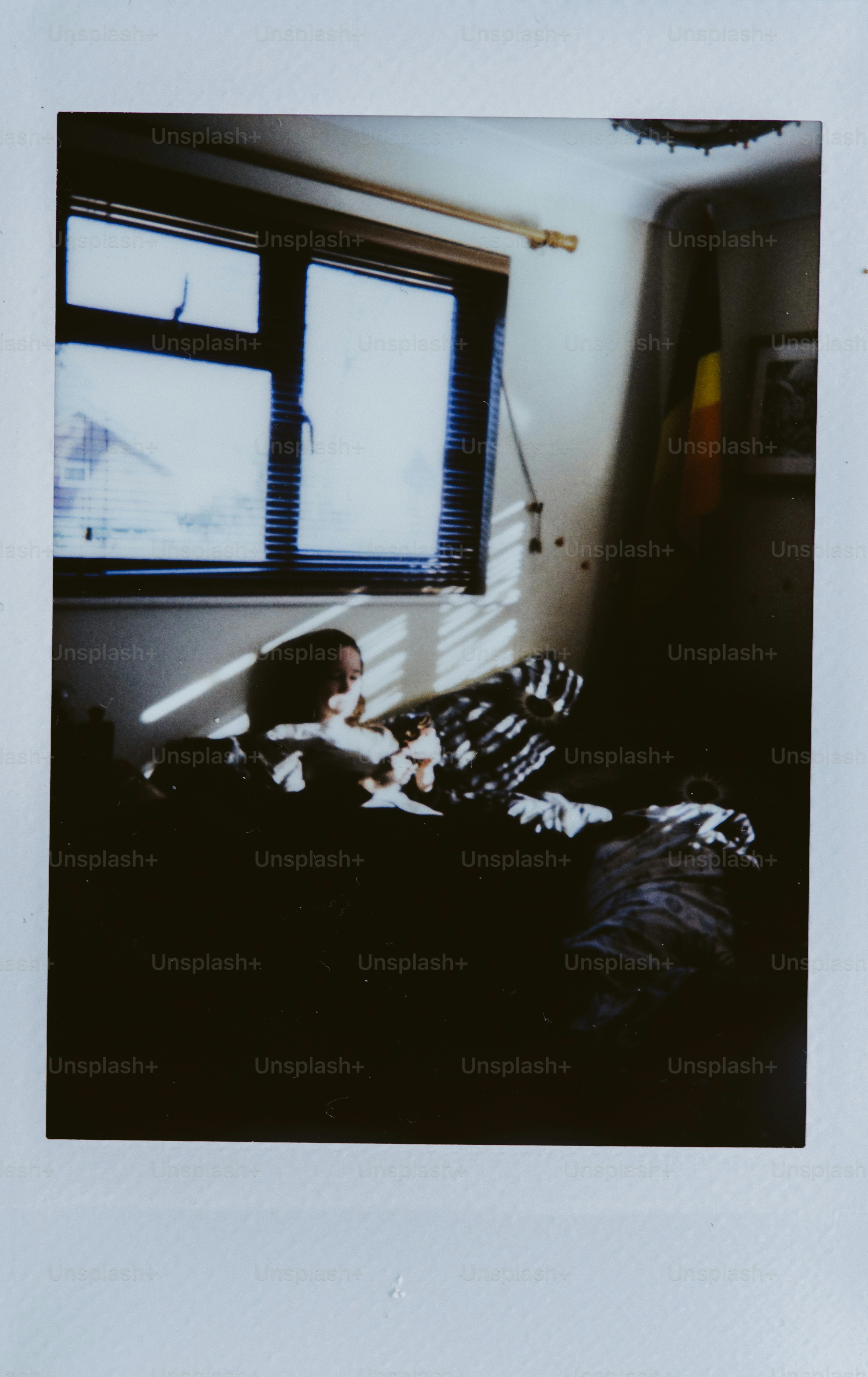 Person in bed with sunlight streaming through blinds.