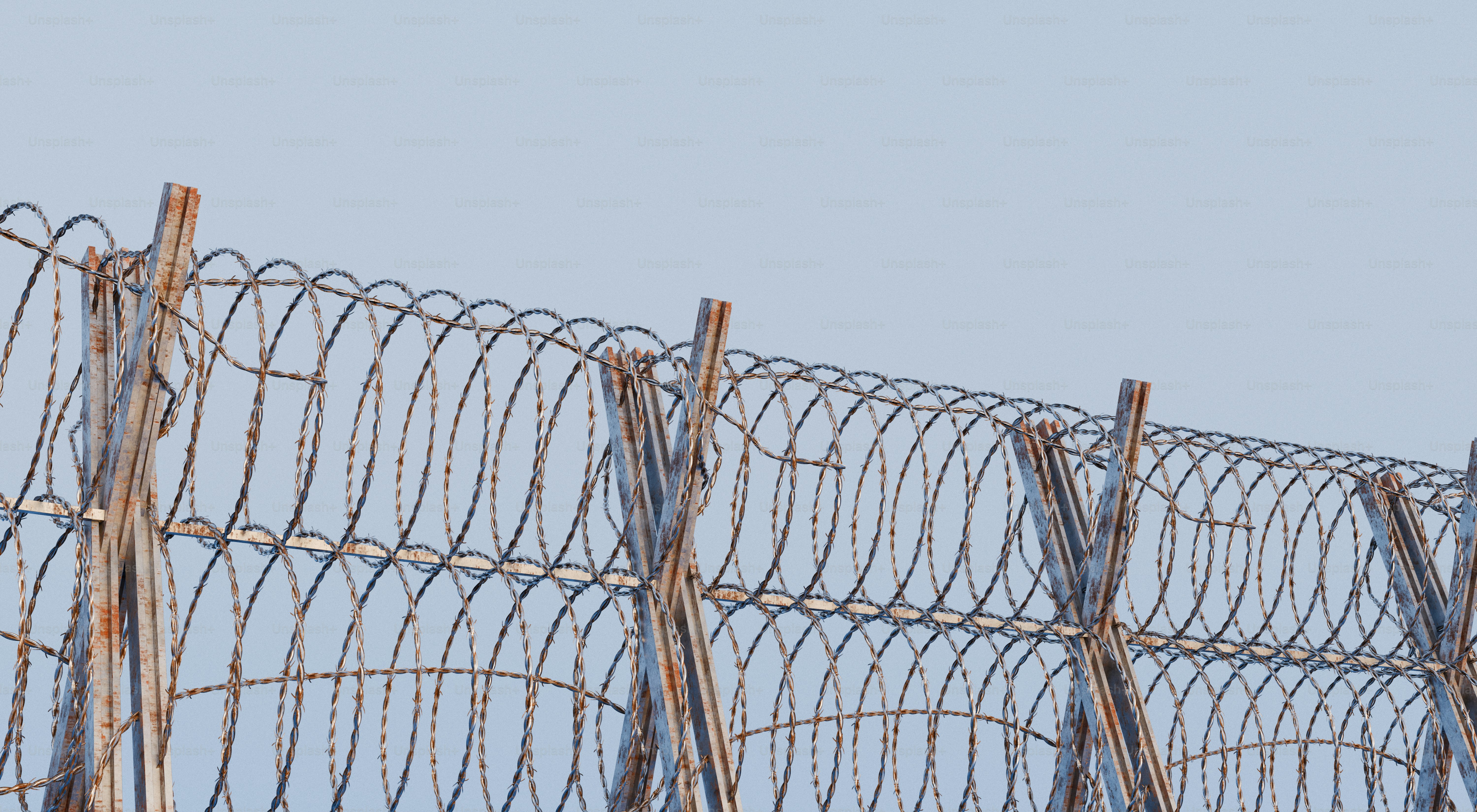 Barbed wire fence against a pale blue sky. photo – 3d render Image on ...