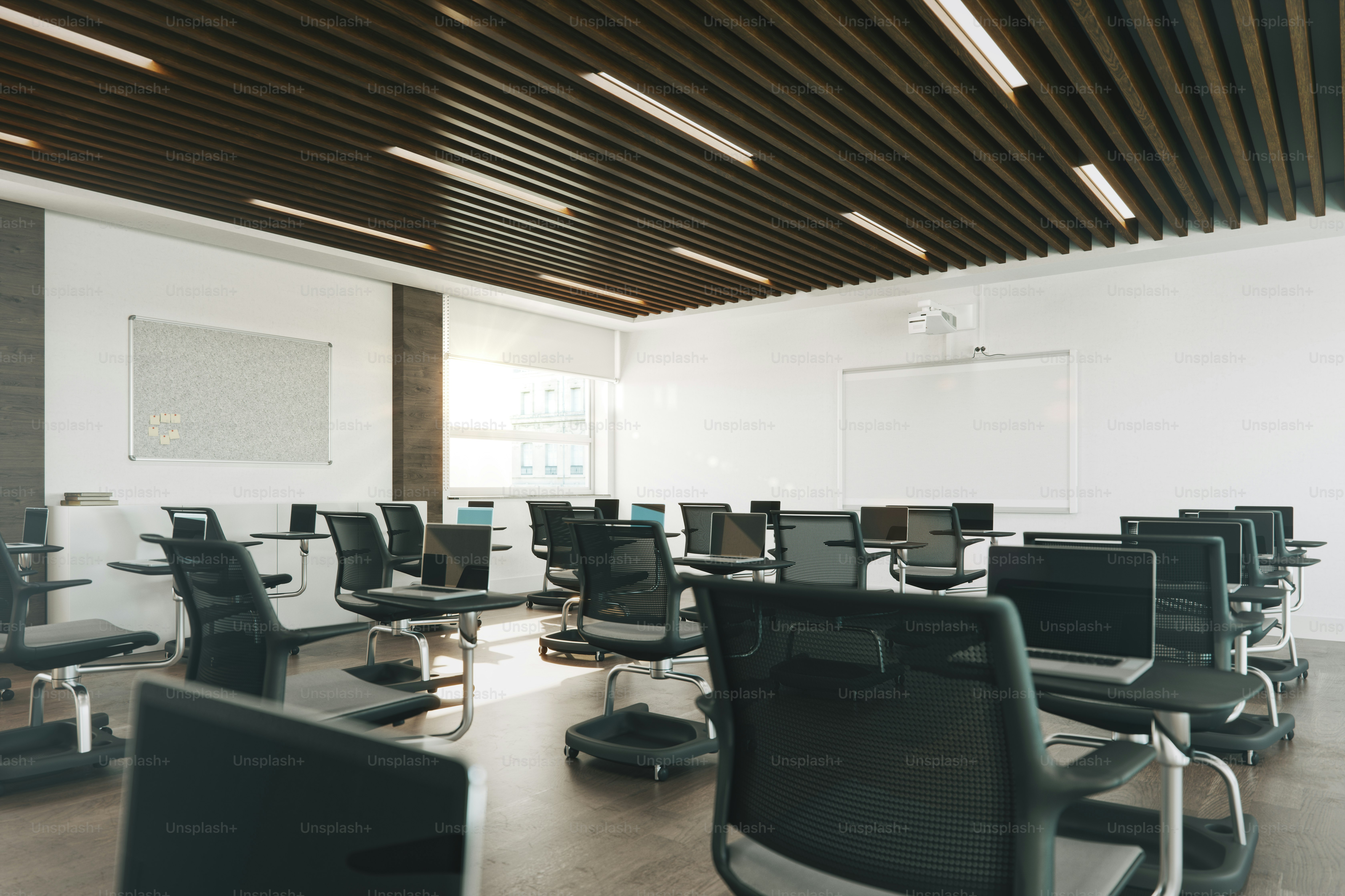 Interior of an empty modern classroom with laptops, interactive whiteboard and chairs organized for social distancing