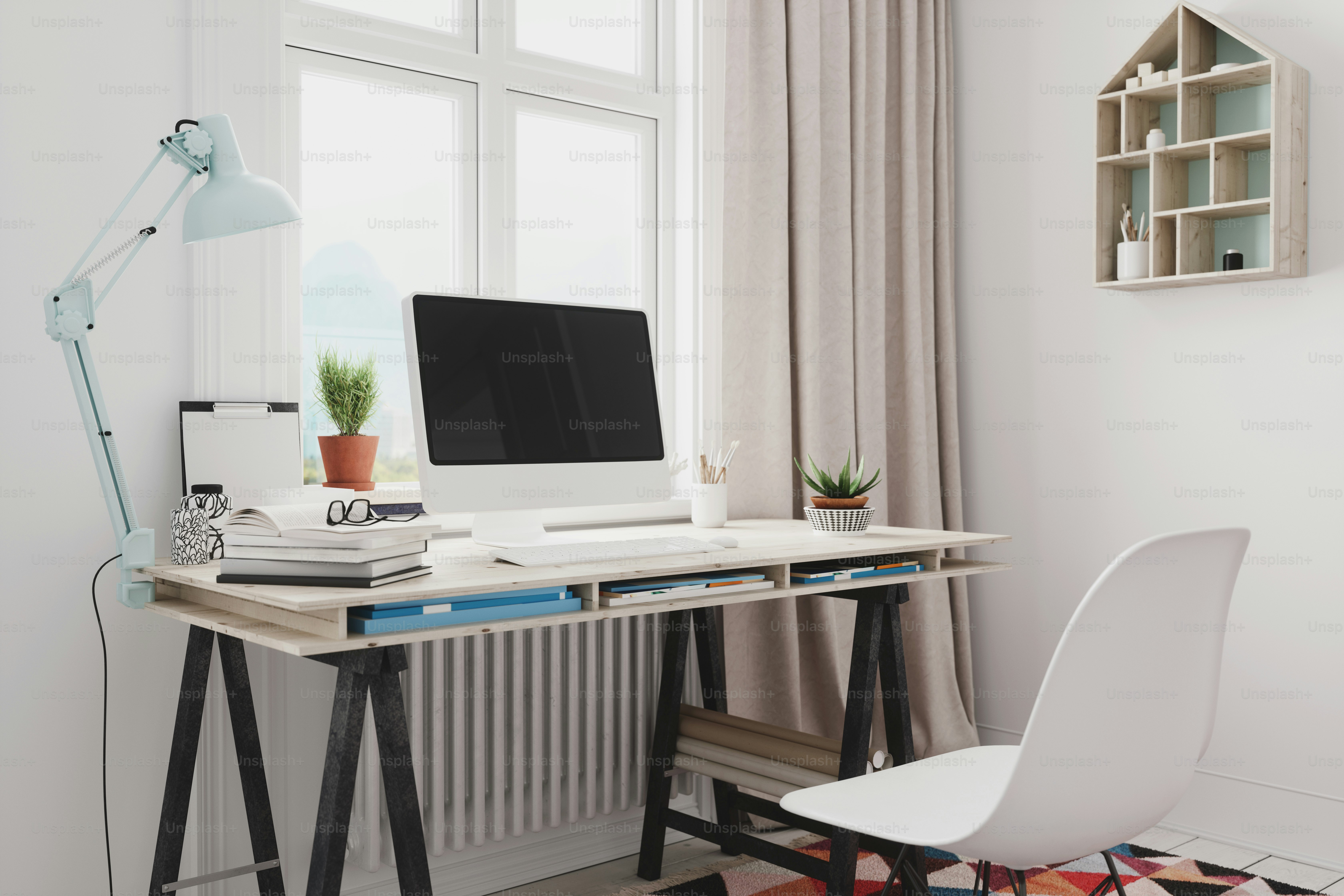 Interno di un ufficio domestico vuoto con scrivania, computer e libri.