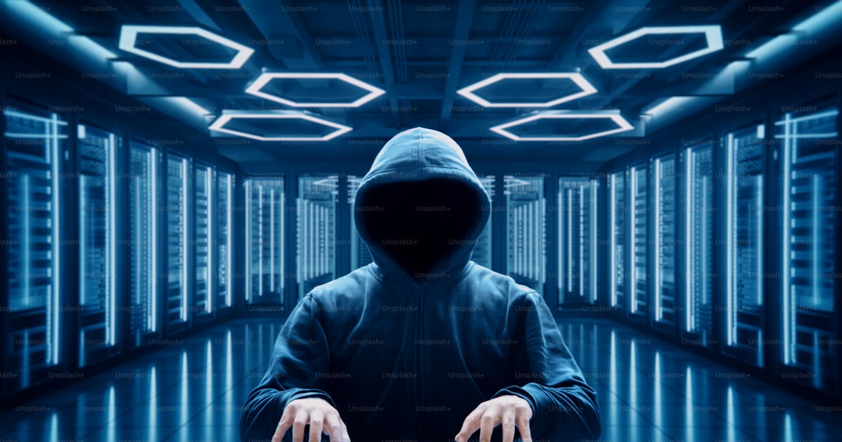 Anonymous hacker writing code with virtual keyboard in server room ...