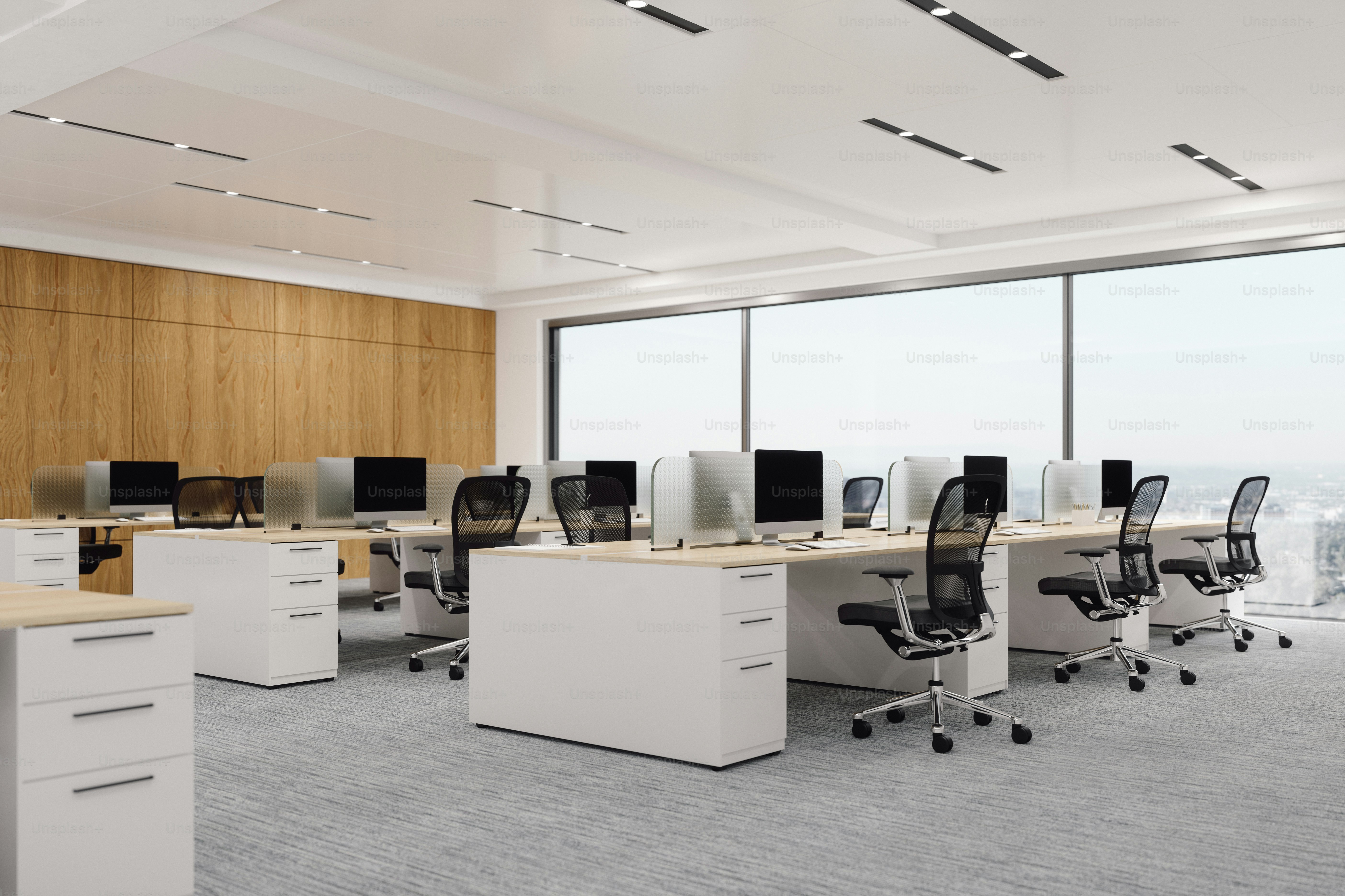 Interior of a modern office space with chairs, desks and computers.