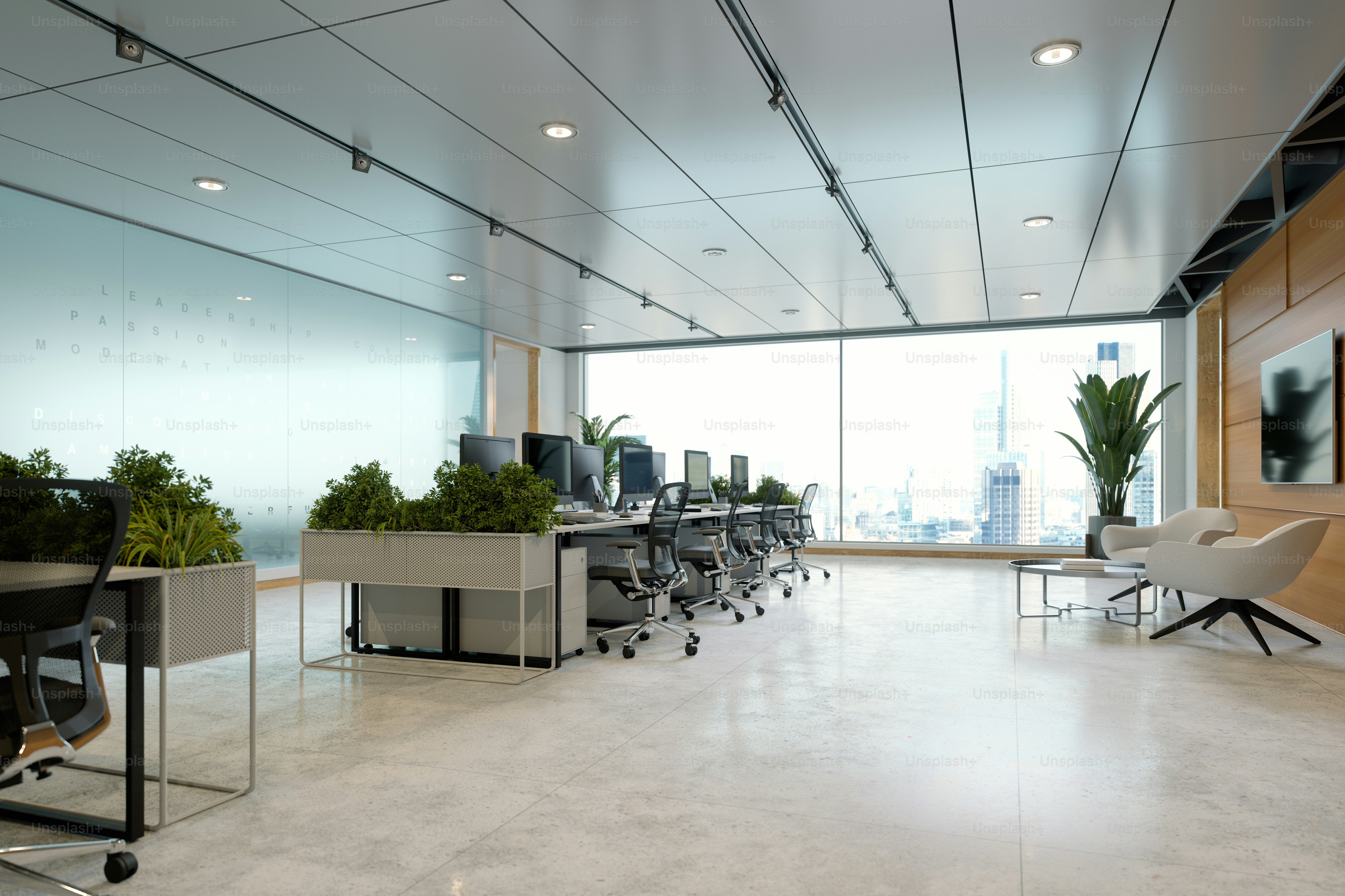 Un espace de bureaux contemporain avec des fenêtres du sol au plafond avec une vue sur la skyline de la ville. Les postes de travail sont équipés de chaises de bureau modernes et de moniteurs, complétés par de la verdure et un coin salon chaleureux.