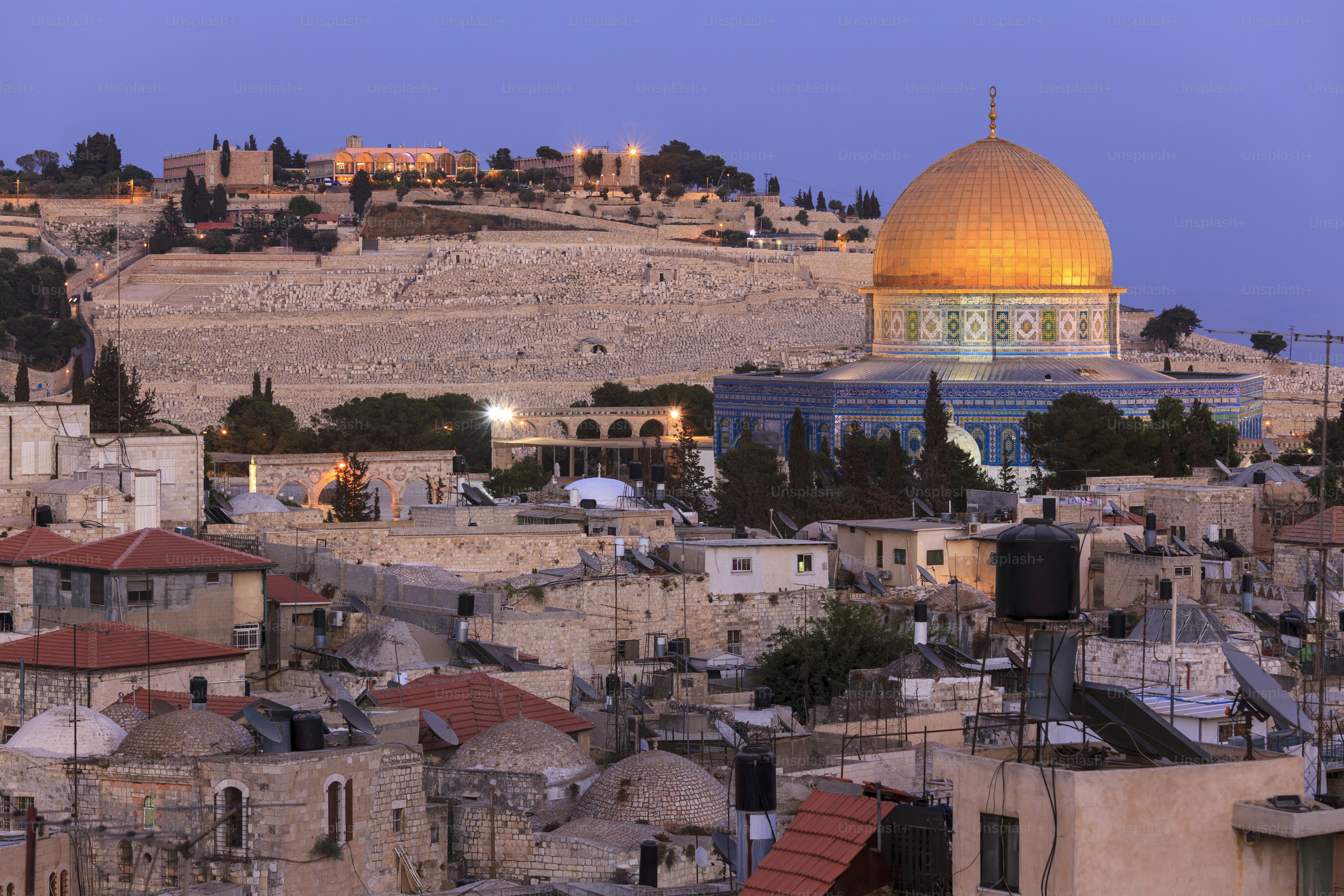 The Dome of the Rock on the Temple Mount and the Jewish cemetery on the Mount of Olives in Jerusalem at dusk, an important religious and historical landscape.