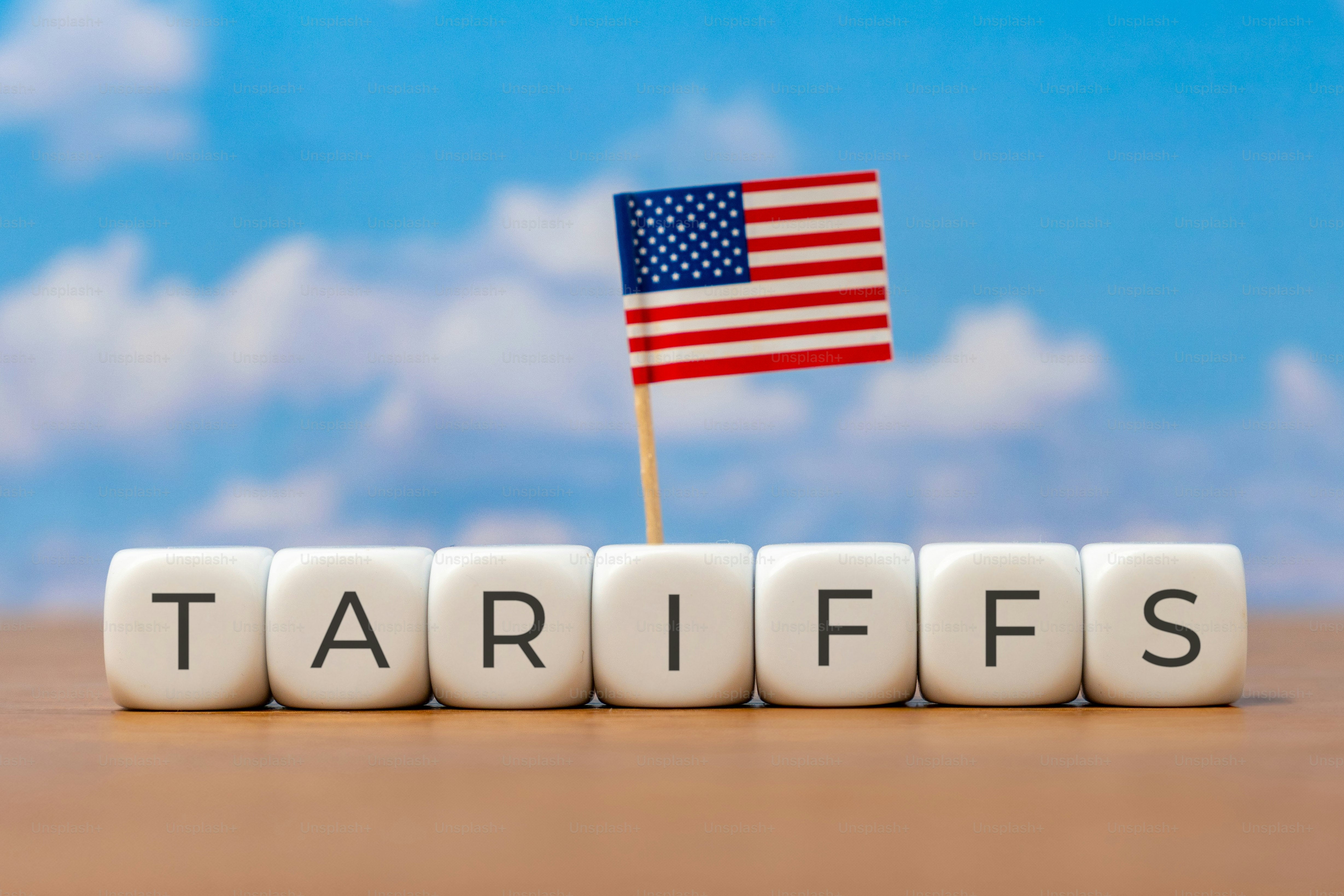 Los cubos que forman TARIFFS están dispuestos en línea con una pequeña bandera americana
