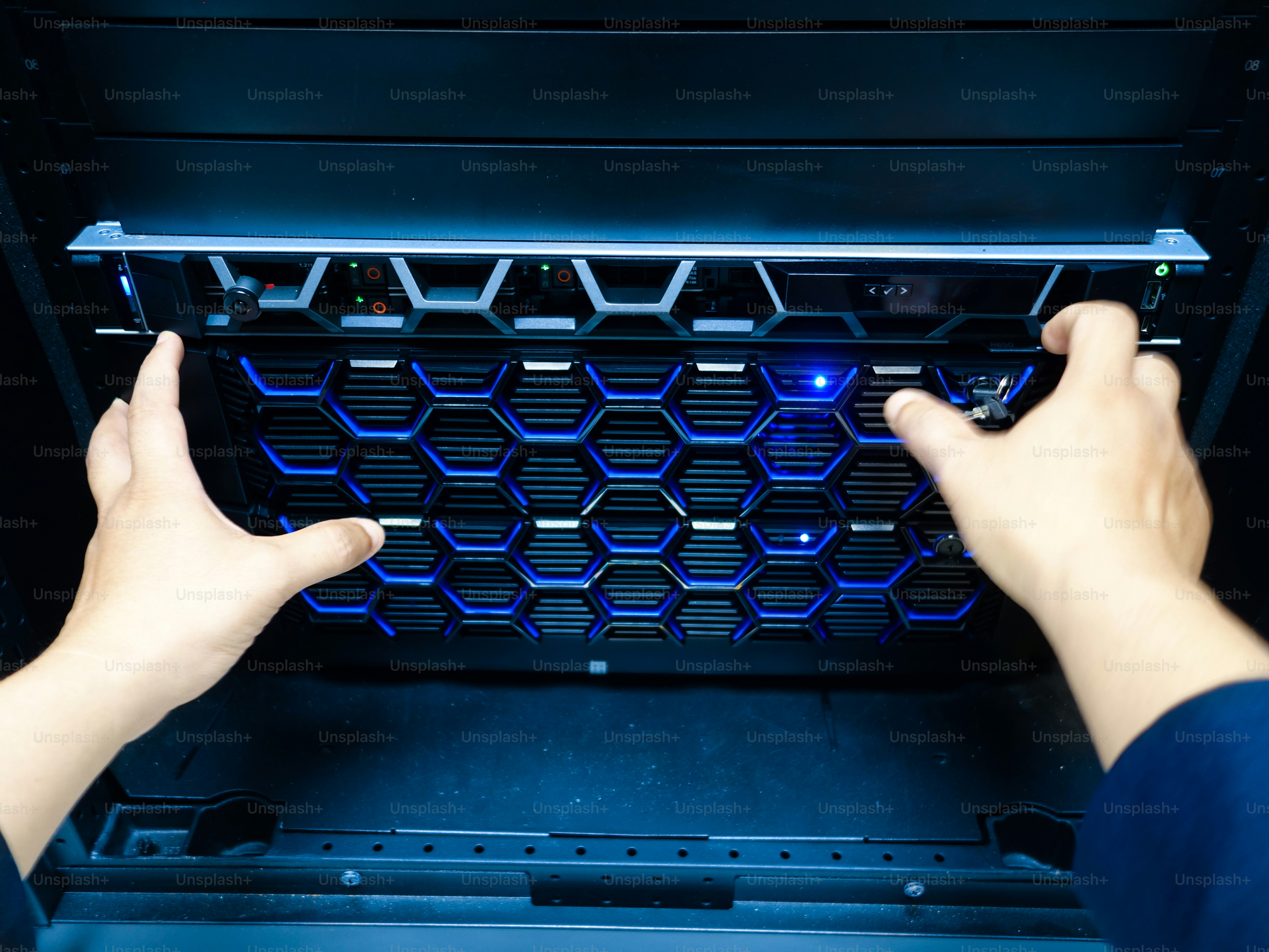 A persons hands are installing a server in a rack unit, showcasing ...
