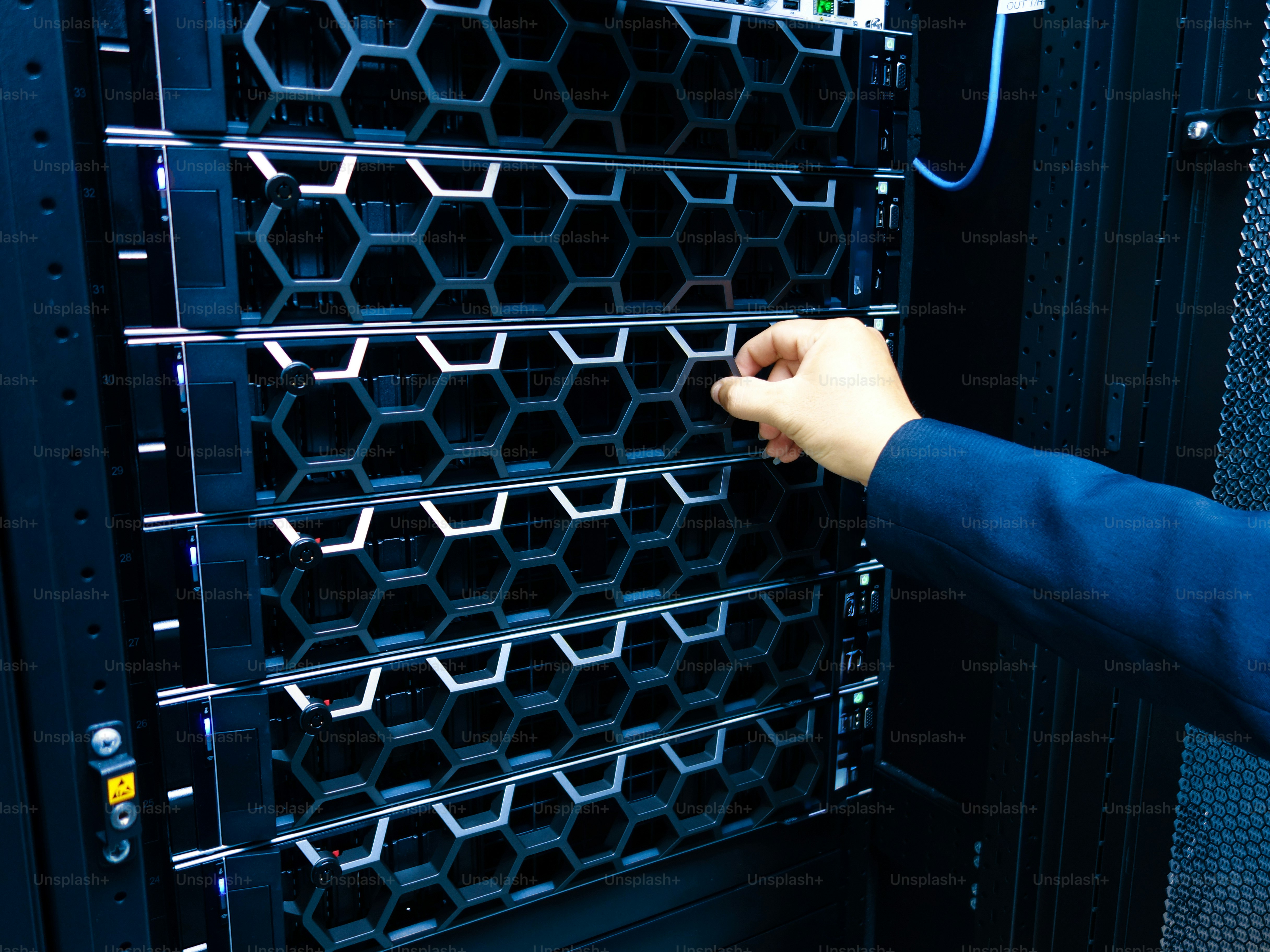A professional hand adjusts a server in a high-tech data center ...