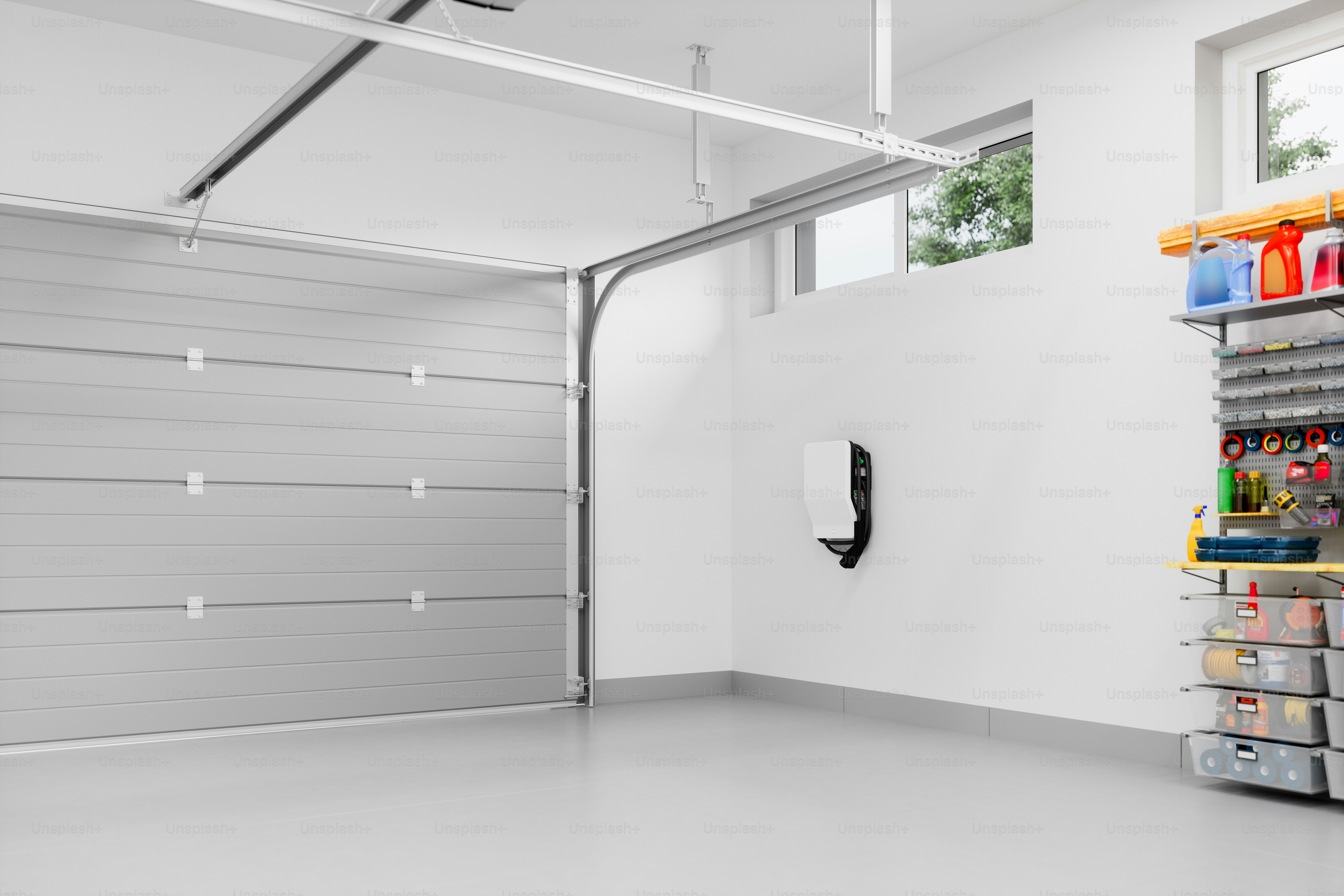 Interno di un garage residenziale moderno e vuoto con caricabatterie per veicoli elettrici.