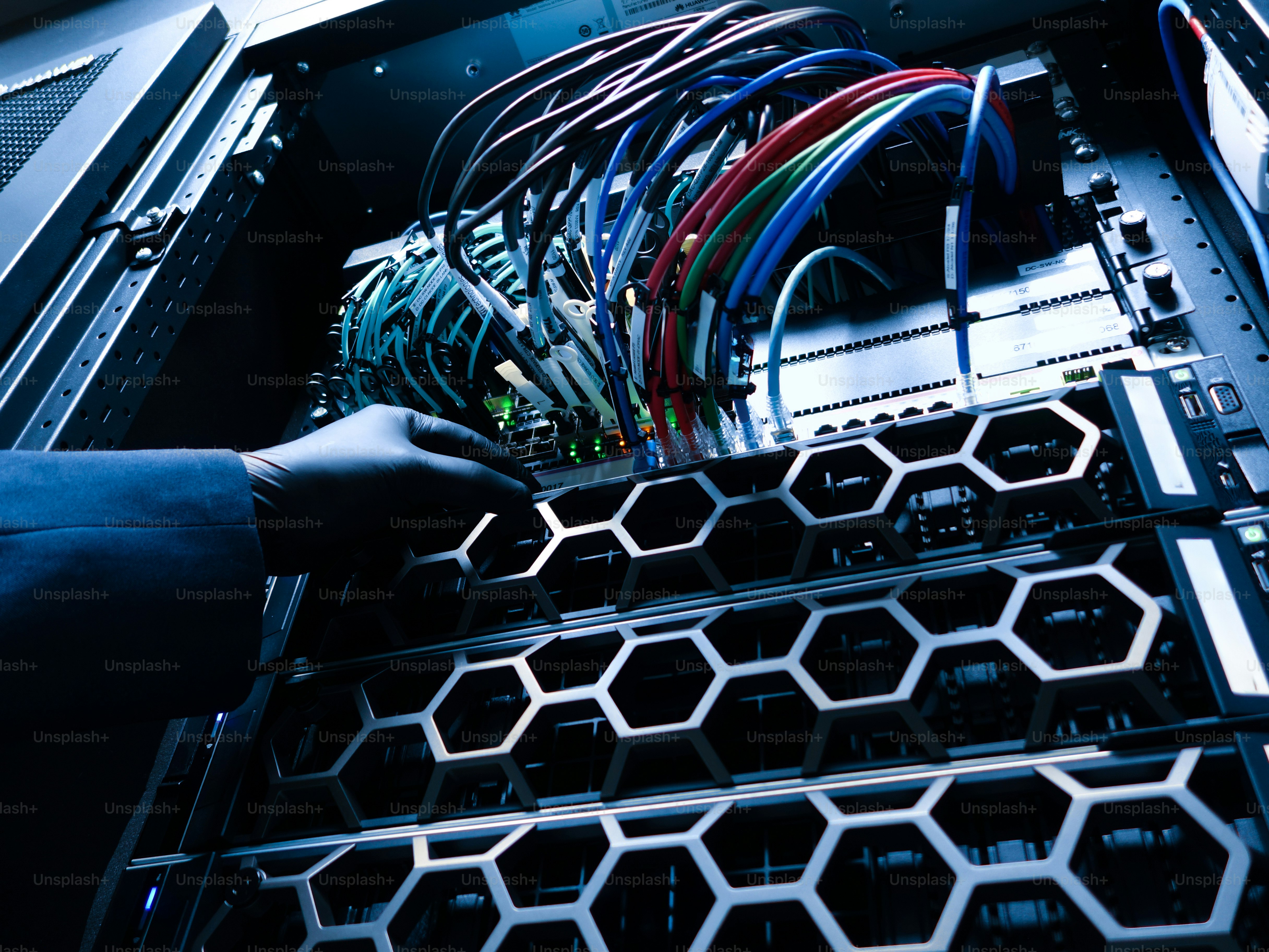 Un técnico realiza el mantenimiento de los servidores en un centro de datos moderno. La imagen destaca un cableado intrincado y equipos de alta tecnología en un entorno seguro.