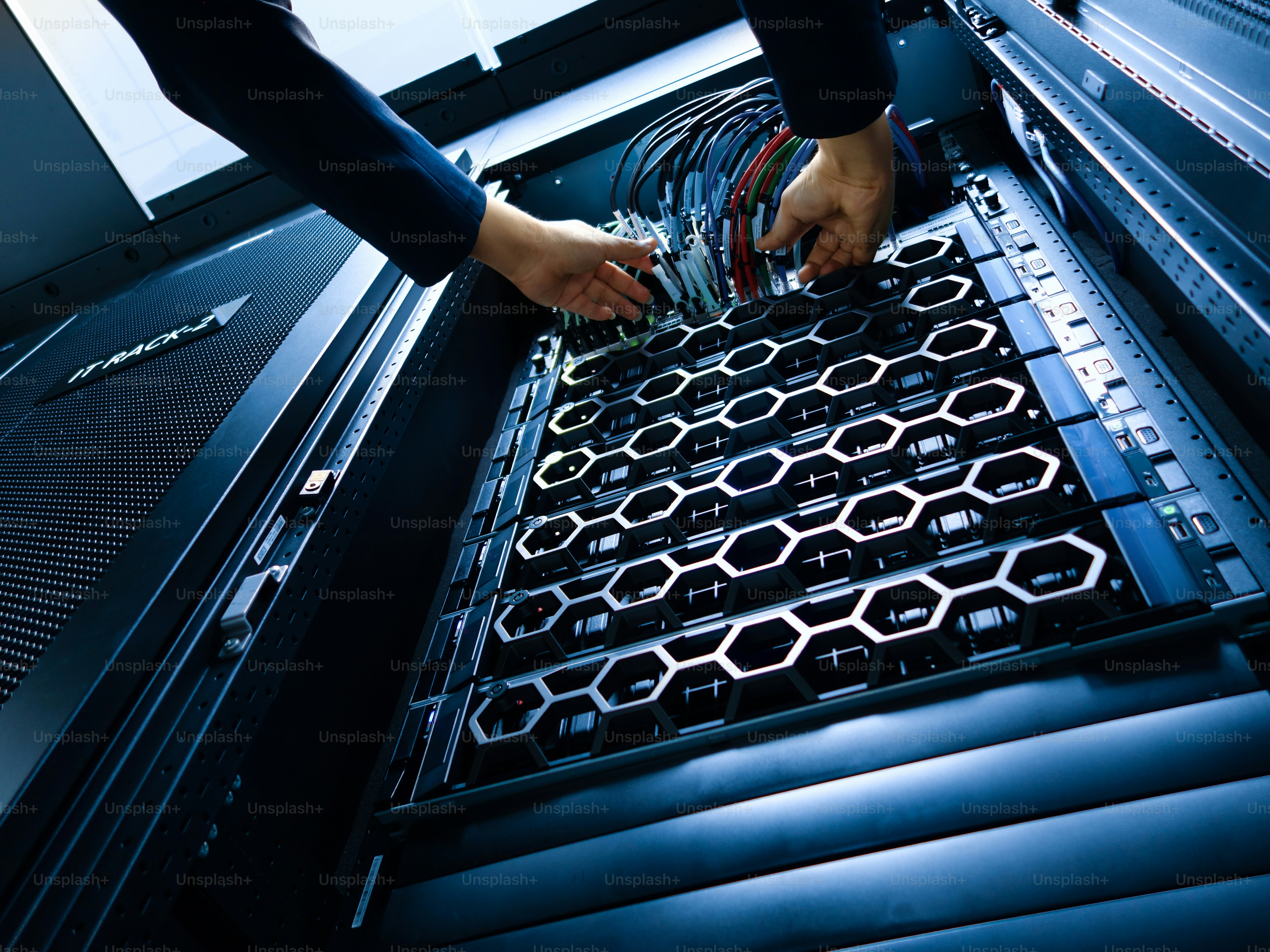 Hands organizing cables in server racks within a modern data center ...