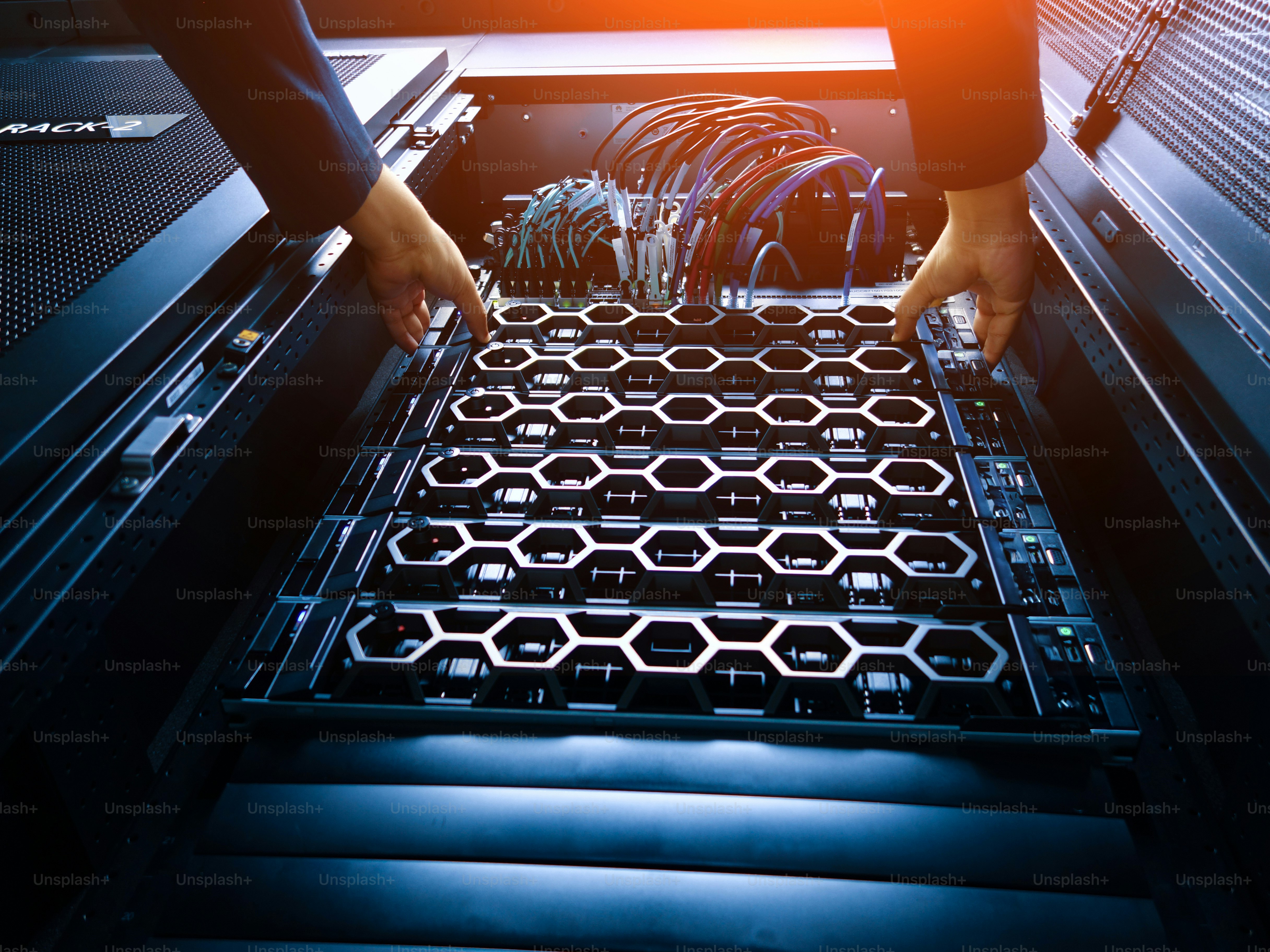 A technician carefully installs server components into a data center rack, showcasing modern technology and hardware management in a professional setting.