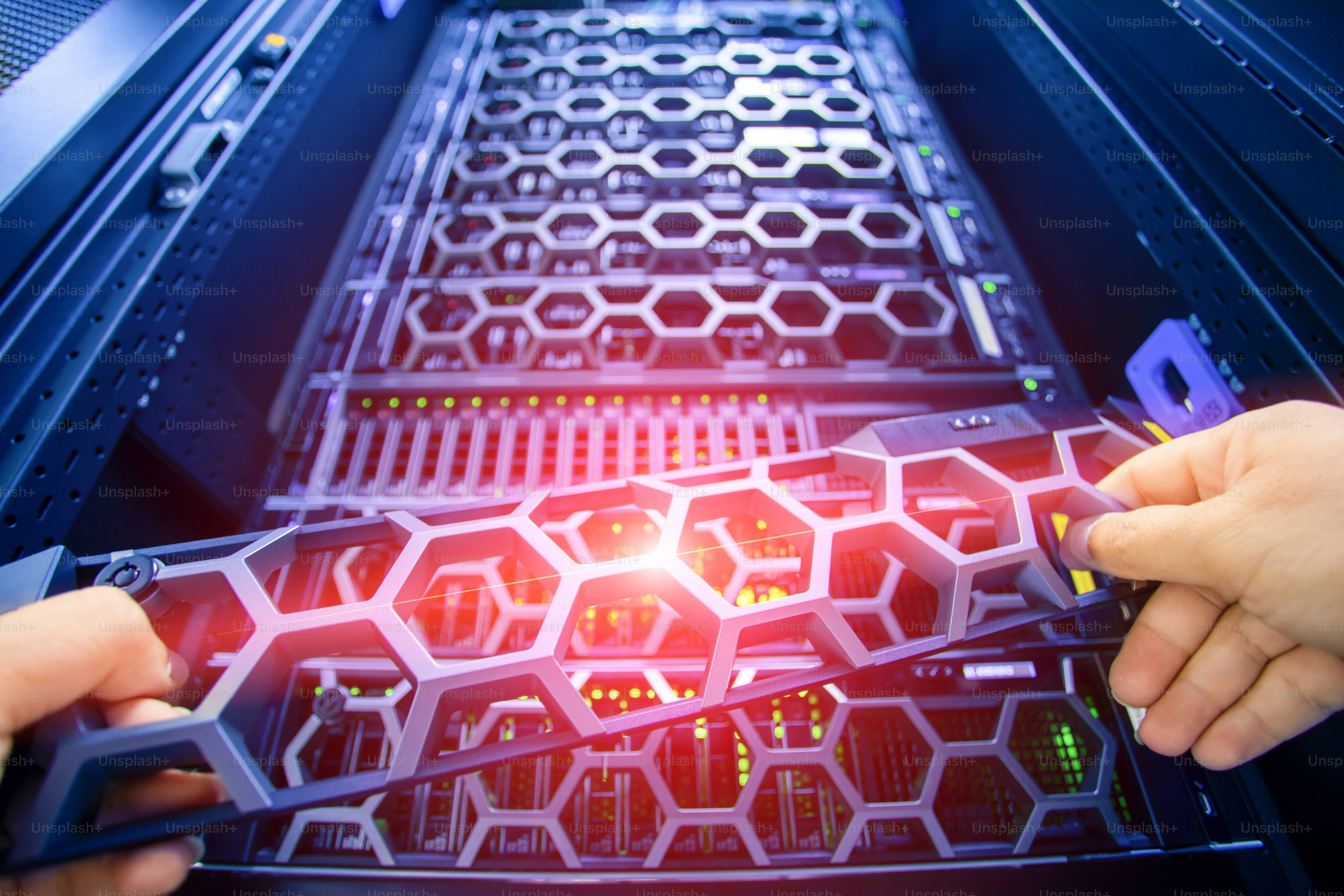 A close-up image of hands installing a component into a server rack ...