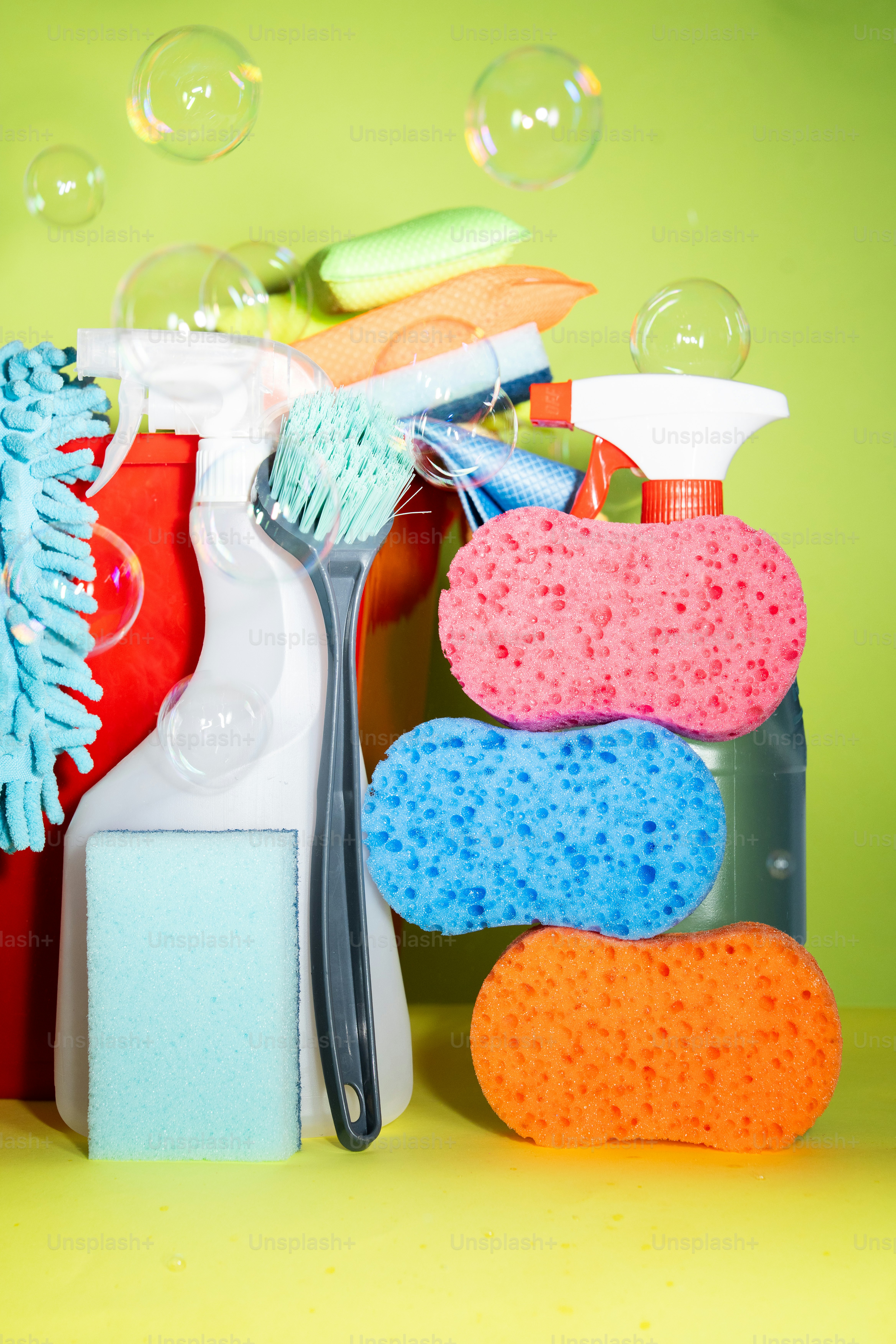 Cleaning supplies with colorful sponges and bubbles