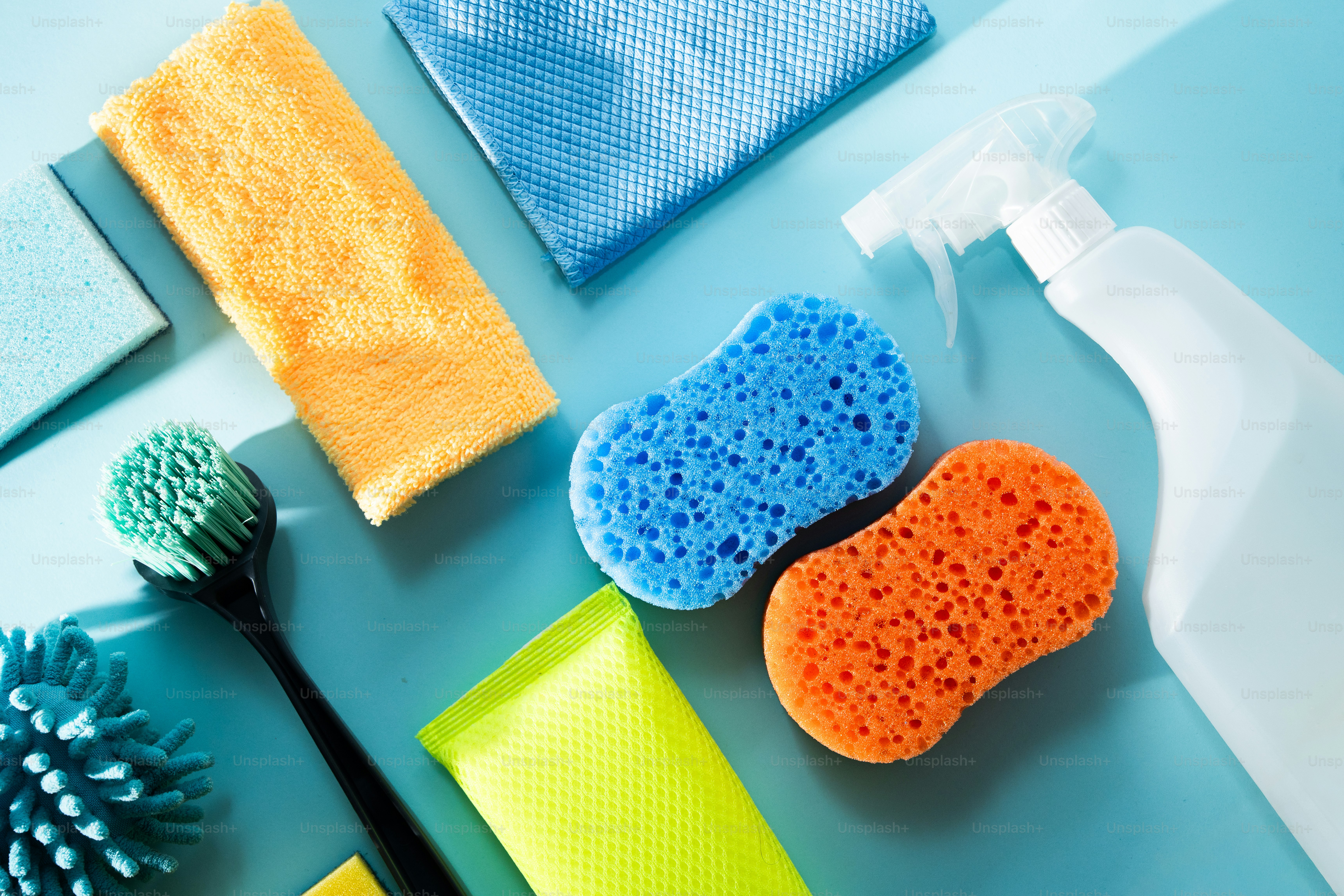 Cleaning supplies including sponges, cloths, and spray bottle.