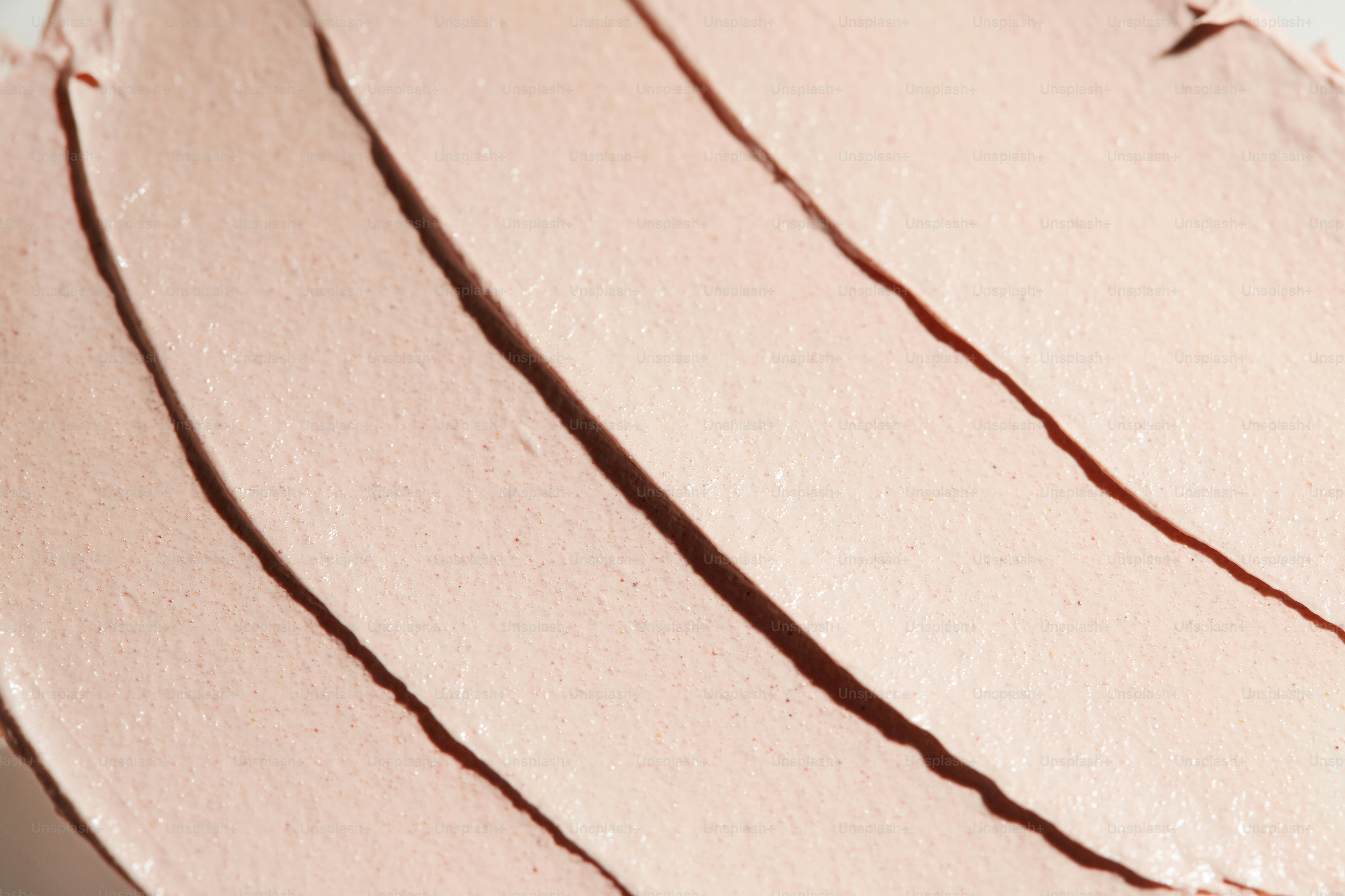 Gros plan sur une crème cosmétique texturée rose pâle