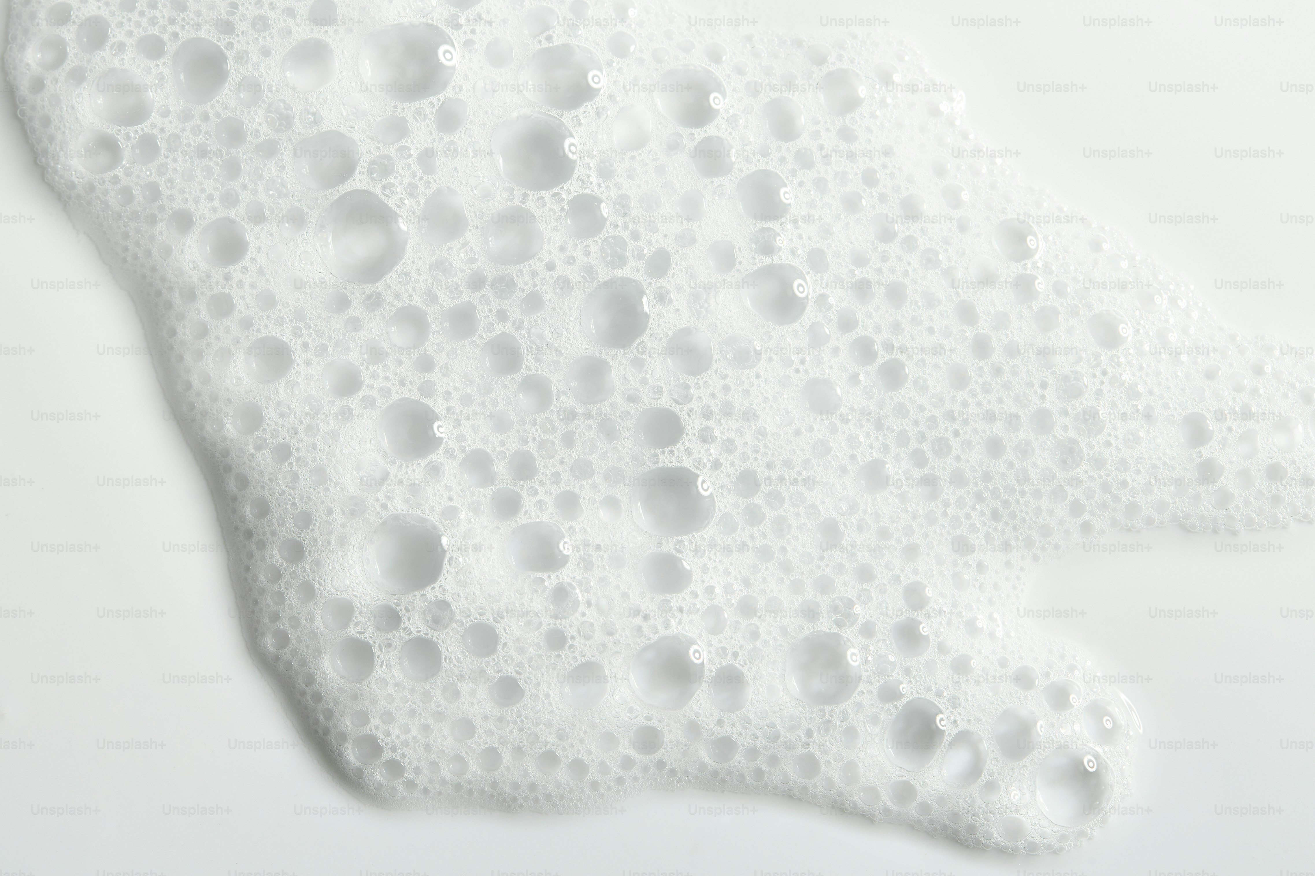 White foam with many small bubbles on a white surface.