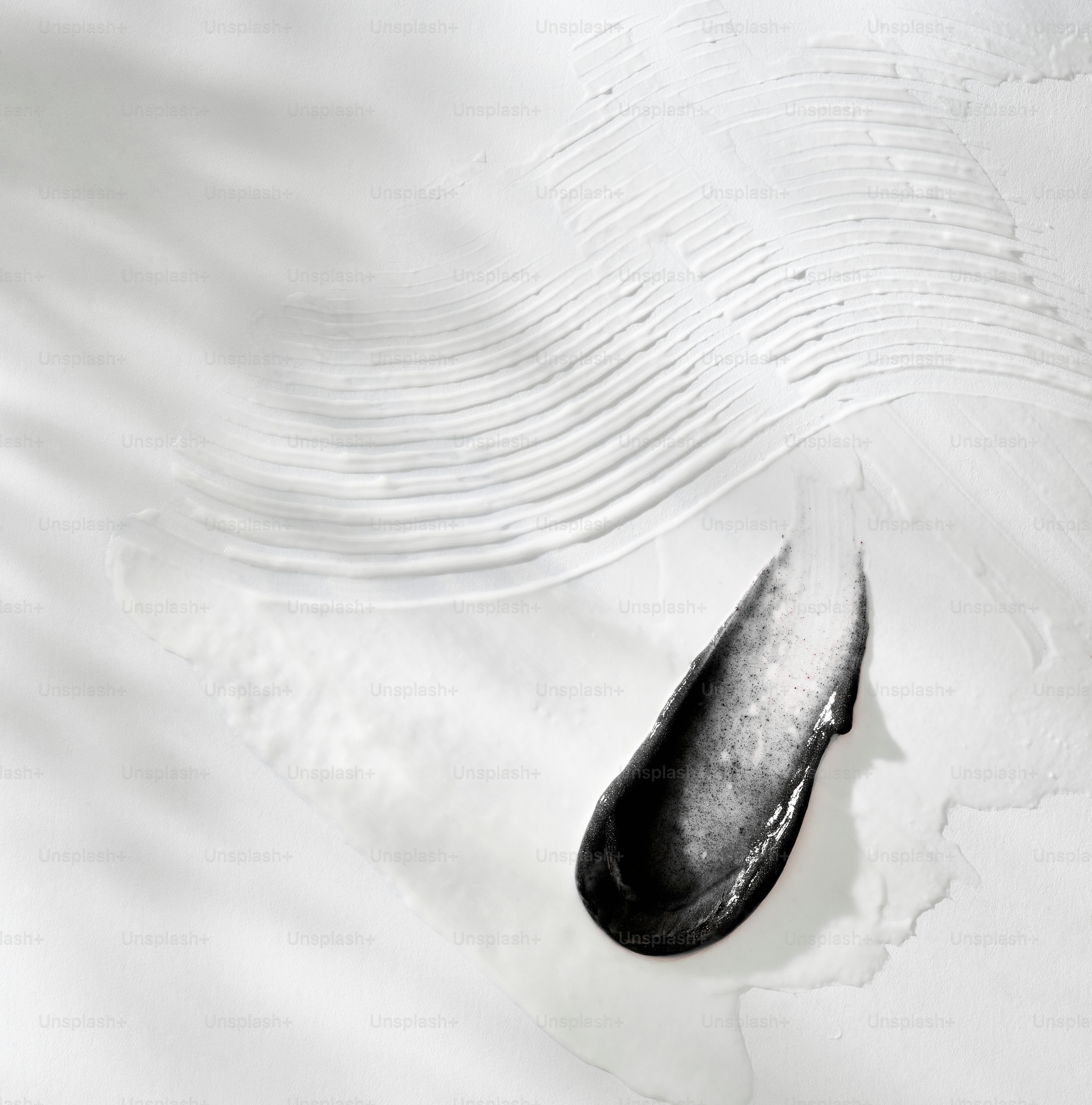 Black charcoal mask smear on white textured surface