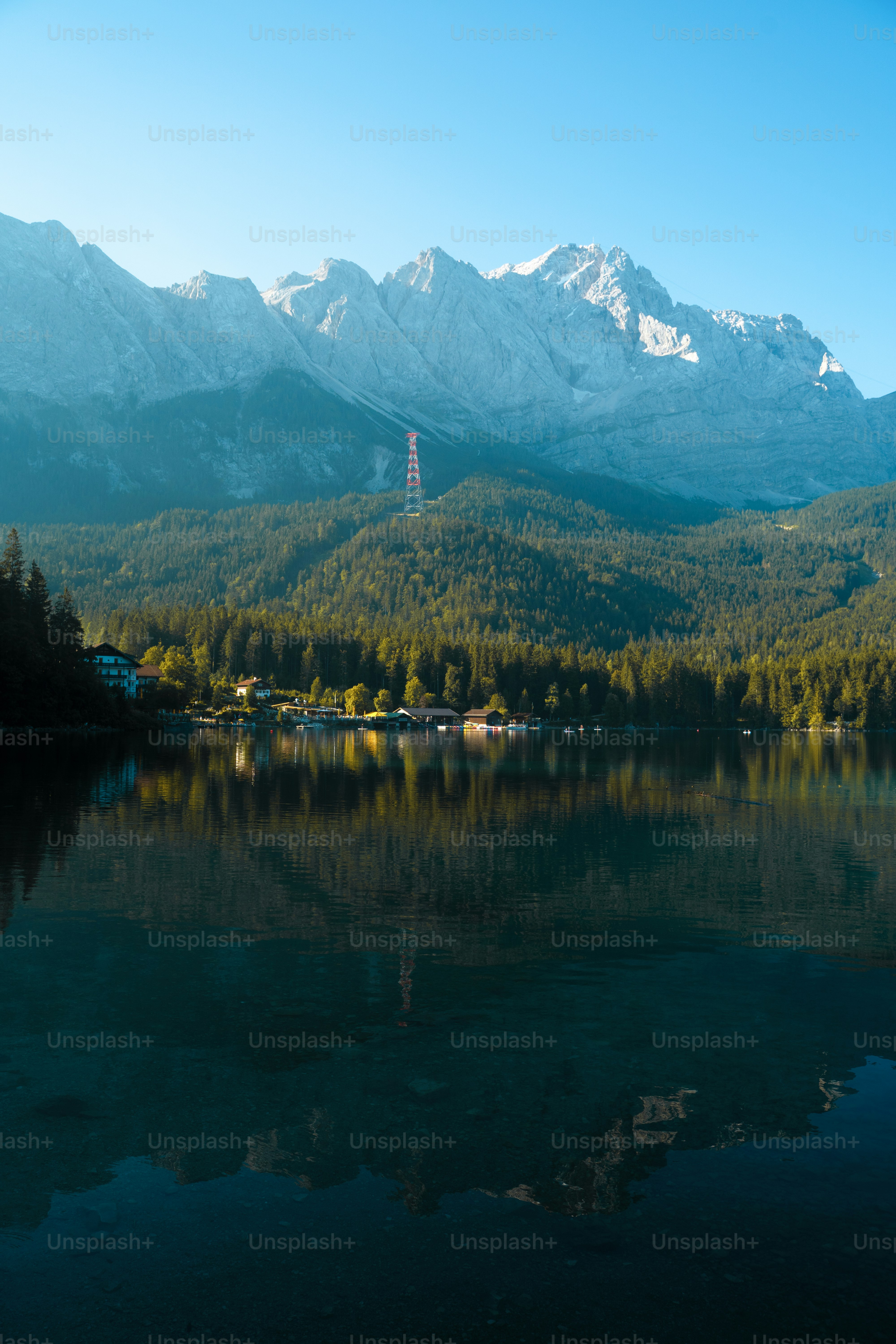 穏やかな湖は山々や森林に覆われた丘を映し出しています。