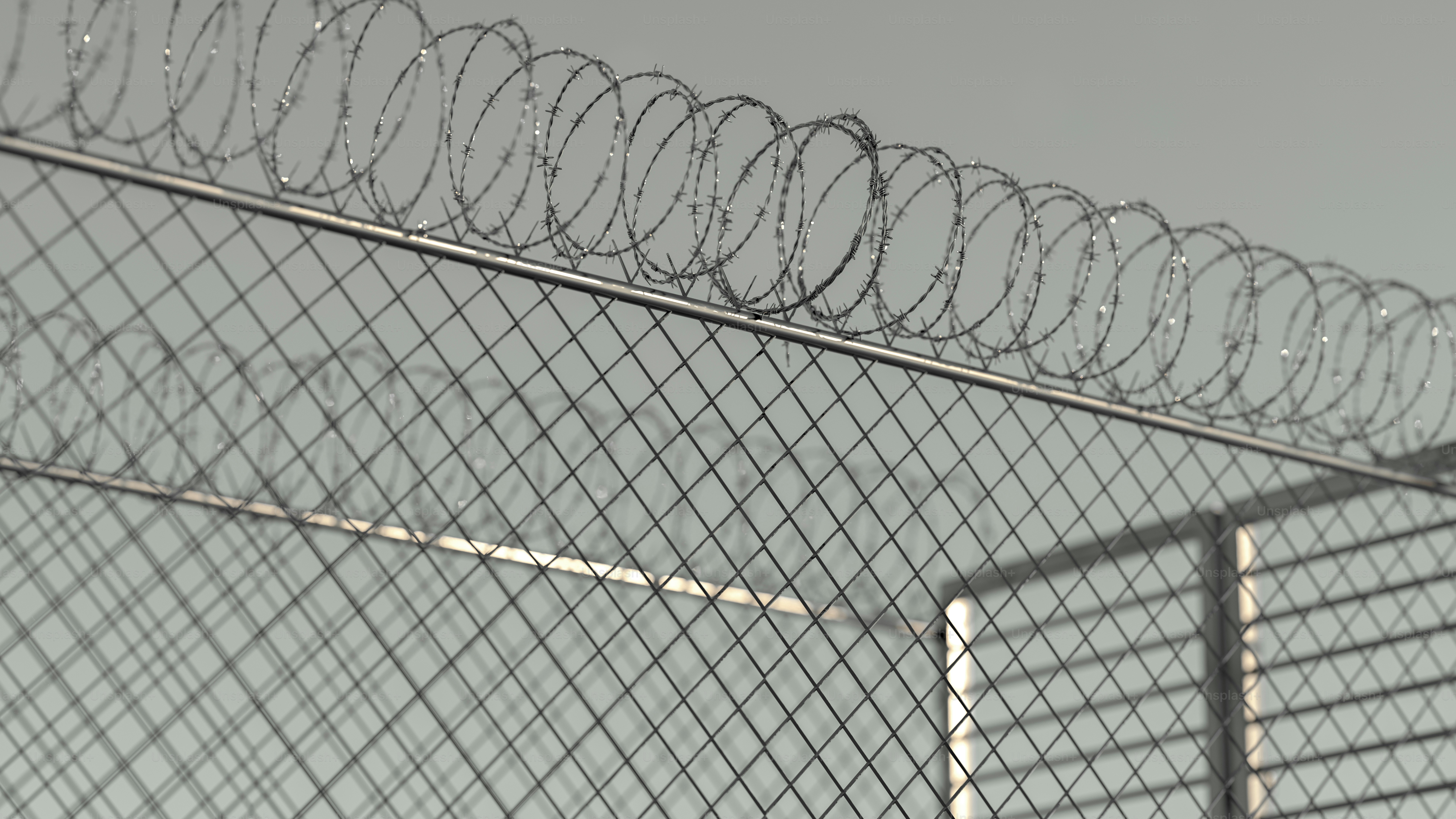 Barbed wire fence against a cloudy sky