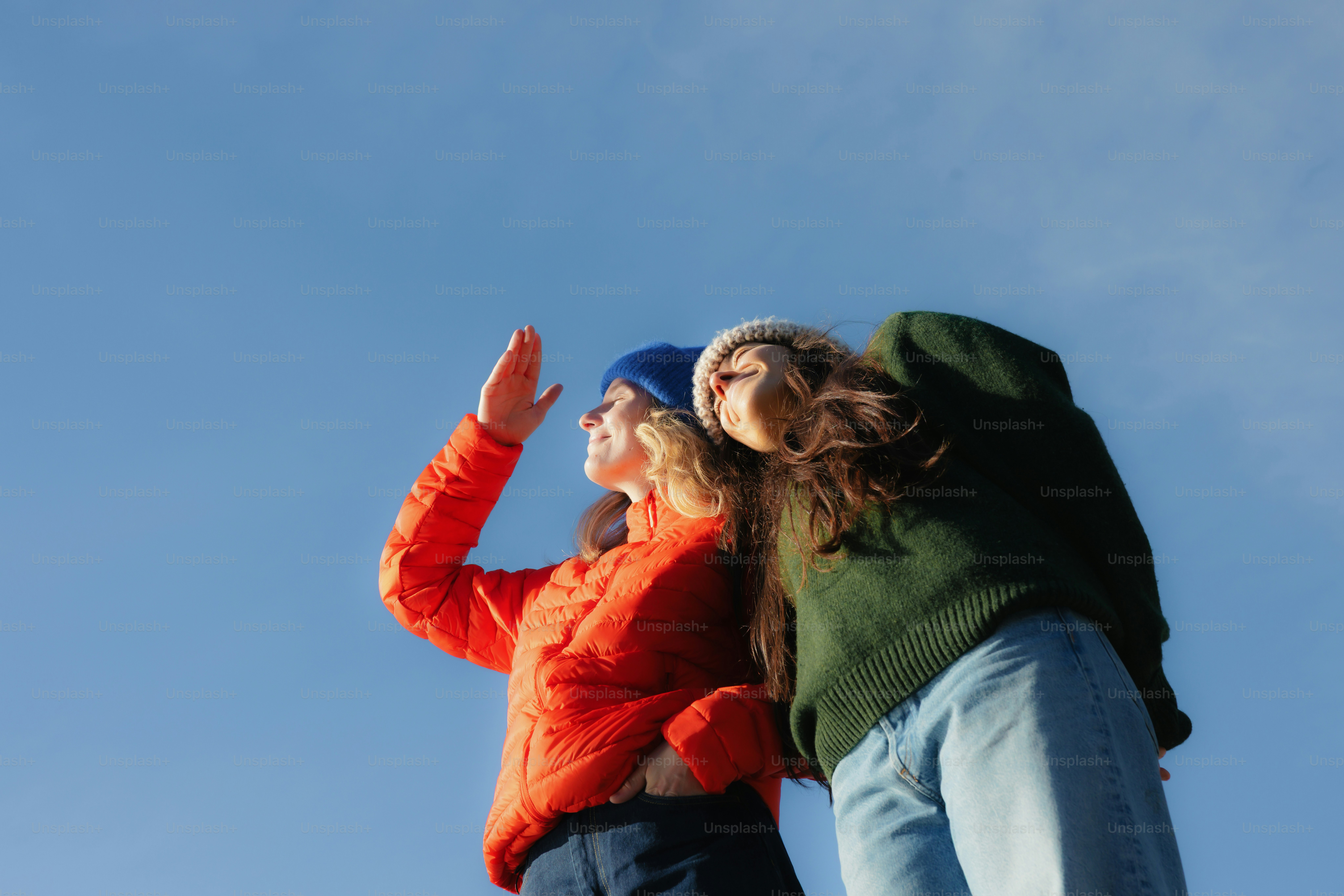 Two women looking up at a clear blue sky