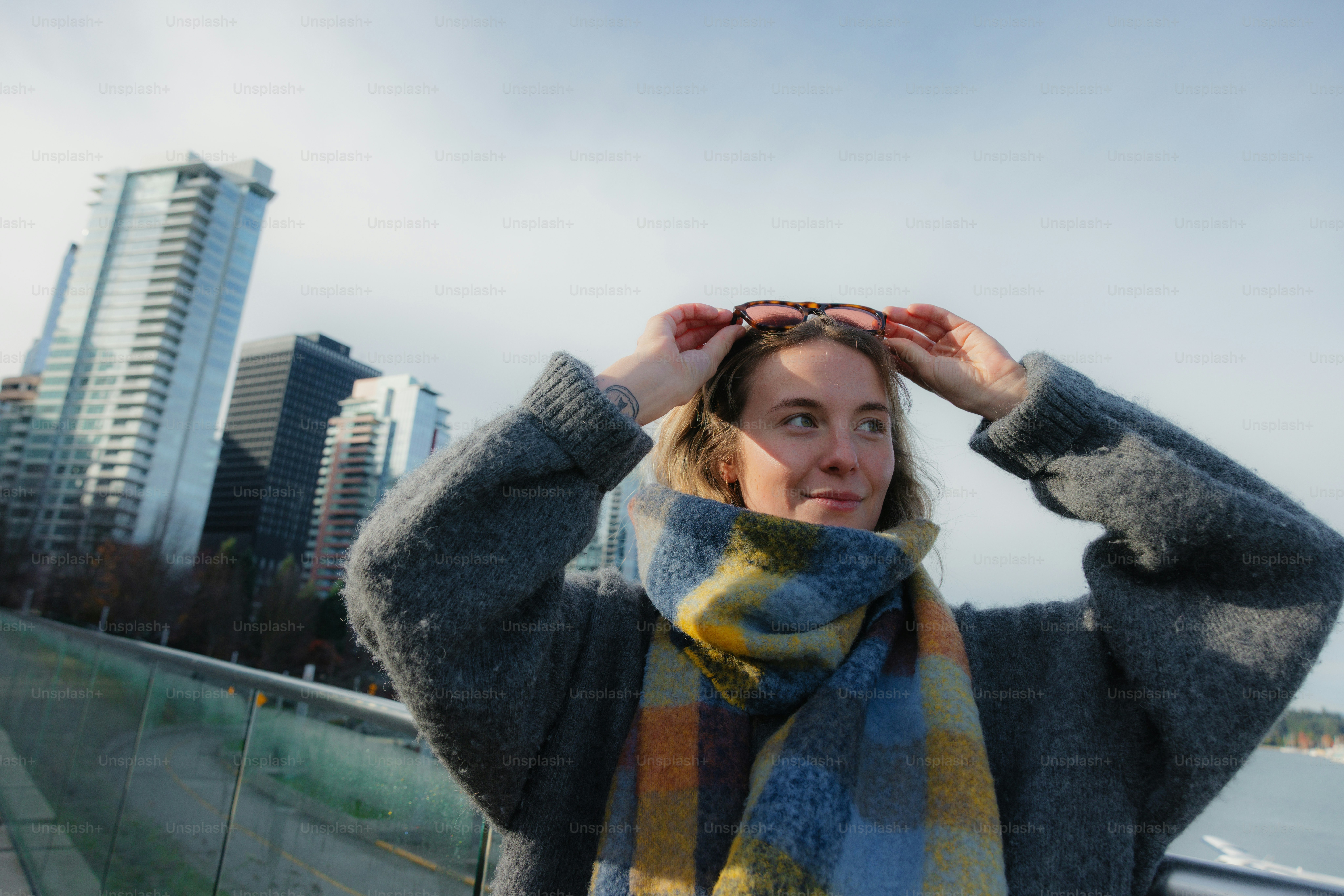 Woman with scarf in front of city skyline