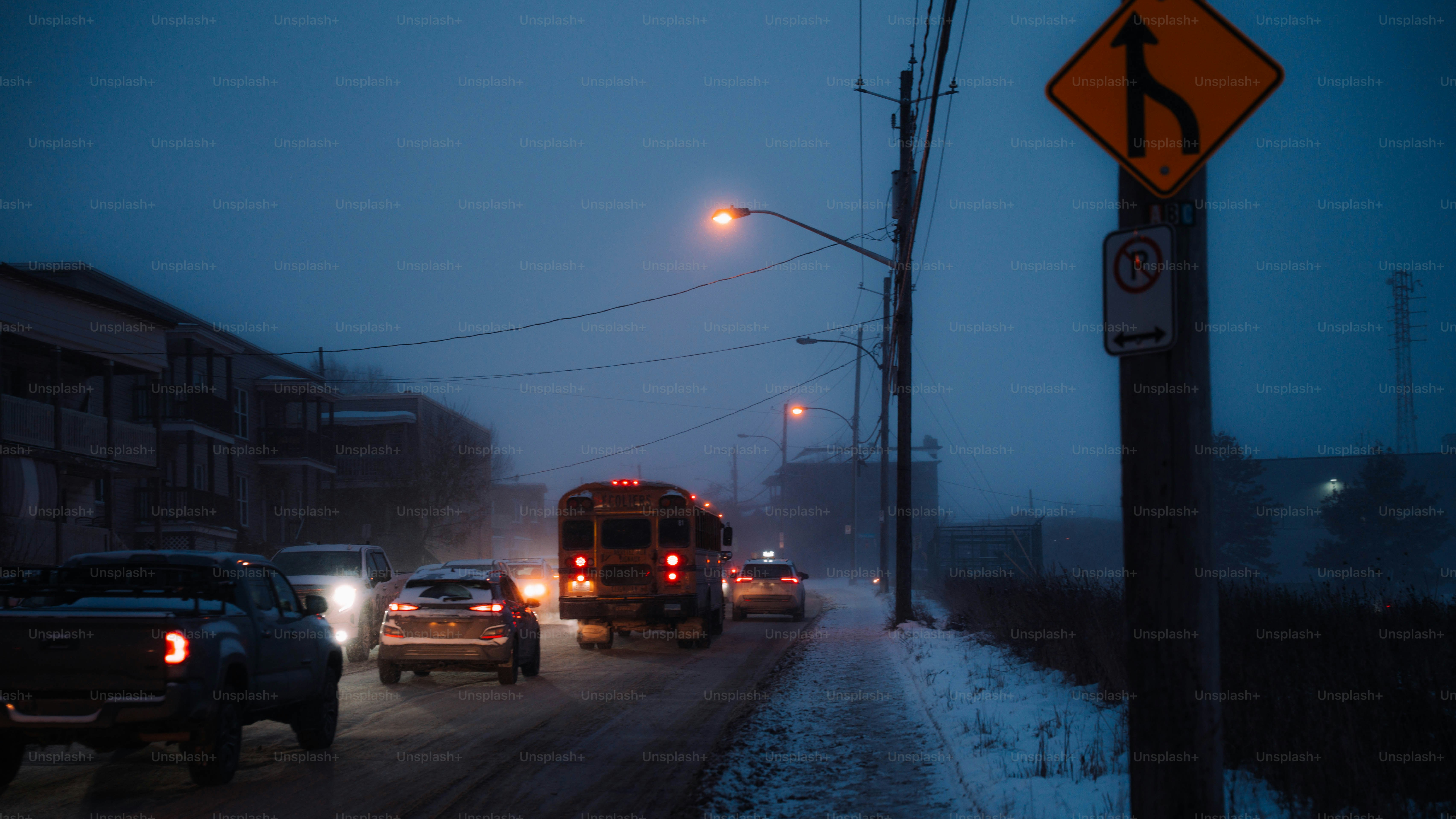 Traffic on a snowy road at dusk